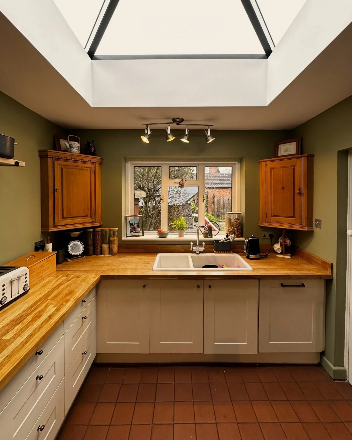 This north facing kitchen was reworked to make better use of natural light, with a roof lantern added to lift the space and make it feel calmer and more usable throughout the day. Traditional detailing, timber worktops and a simple, considered decora