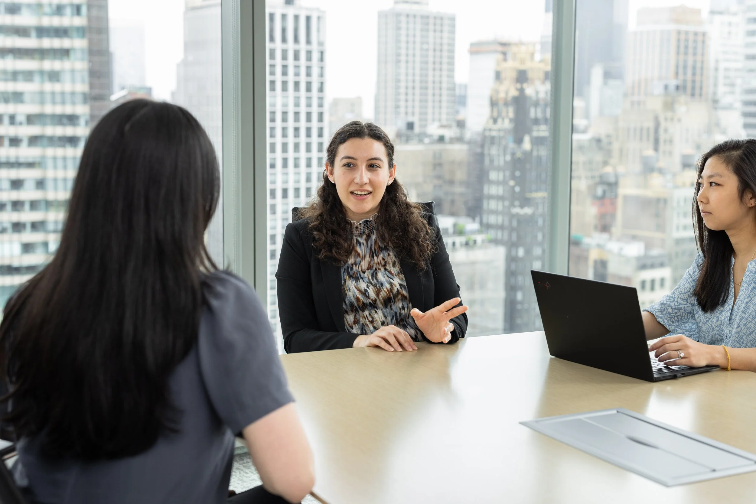 Branding photo showing hree professional women at a meeting in a conference room in New York City midtown offices