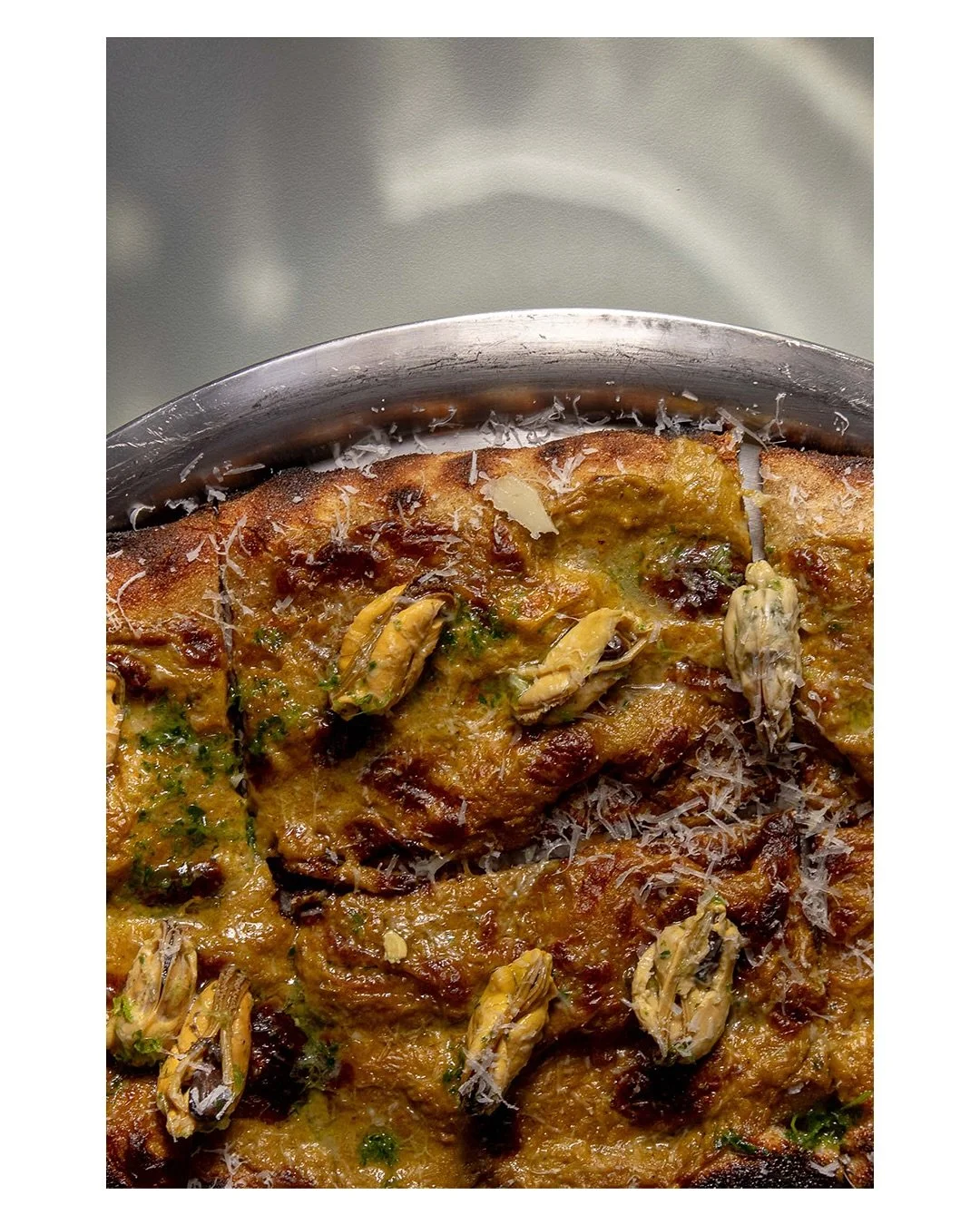 Creativity has no boundaries for our Painza Mussel Crowe with saffron infused pecorino Romano fondue, local mussels, green oil.