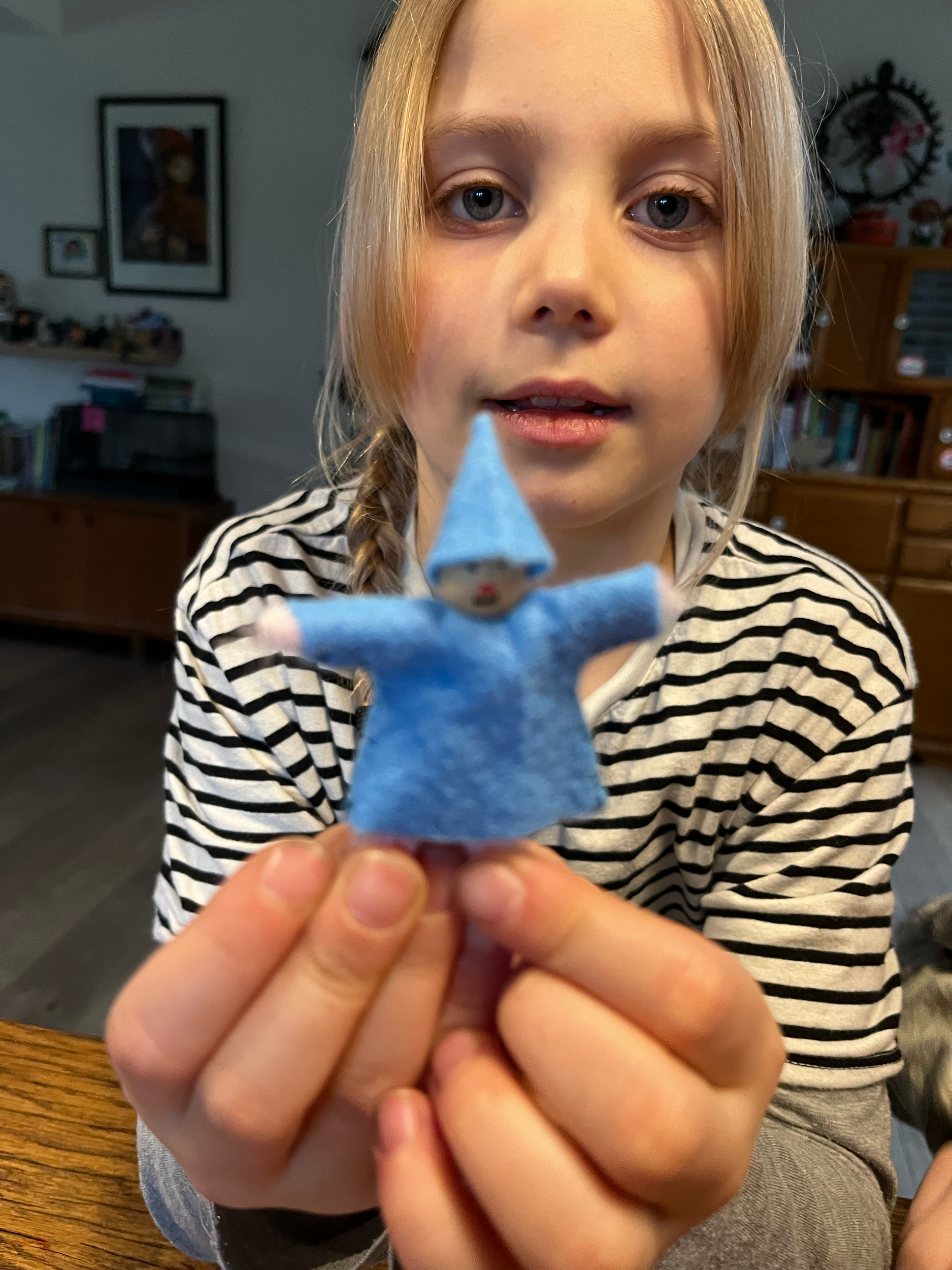 Kind houdt een klein blauw speelgoedfiguurtje vast.