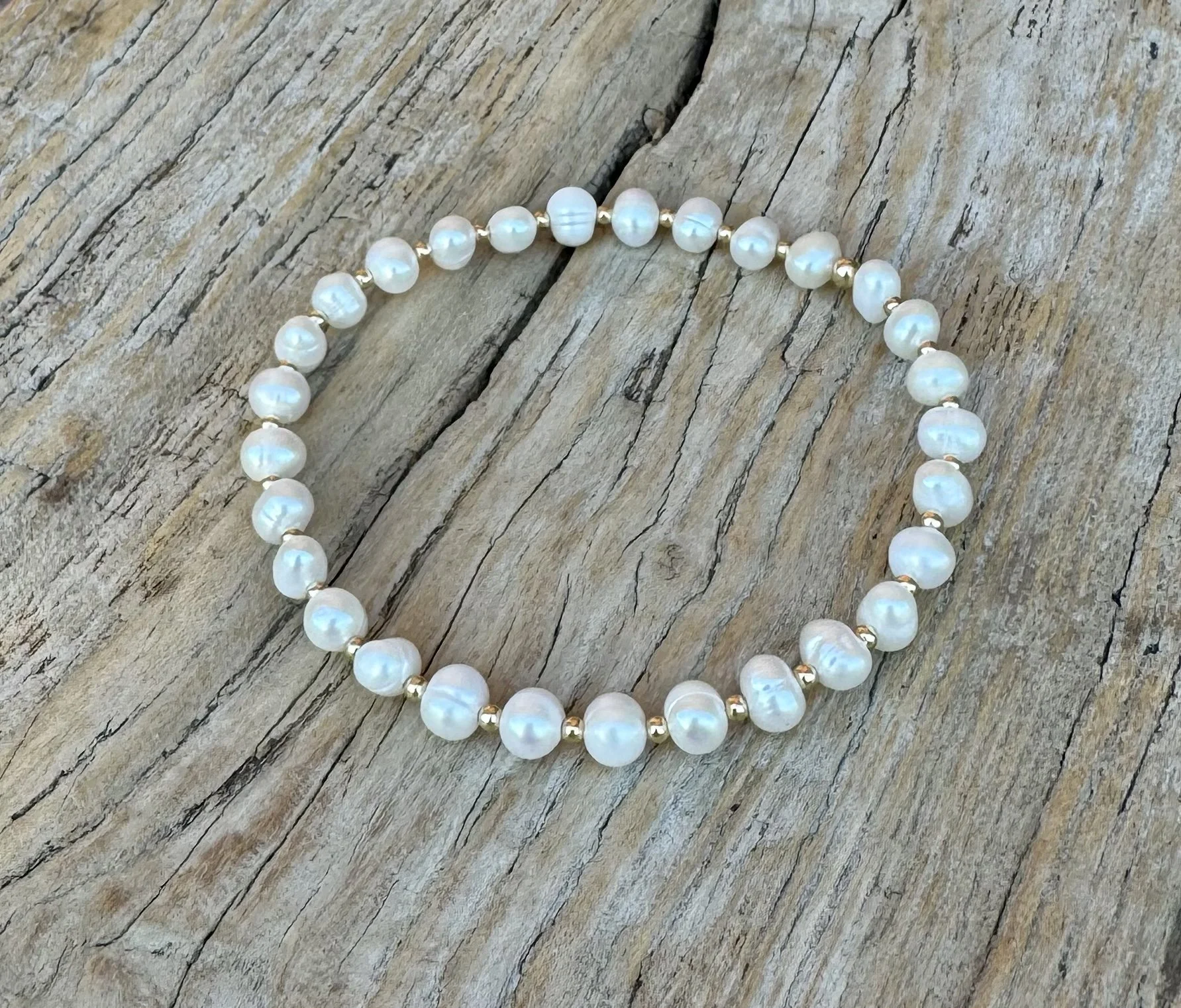 Lucinda Stretch Freshwater Potato Pearl Beaded Bracelet on Wood.jpeg