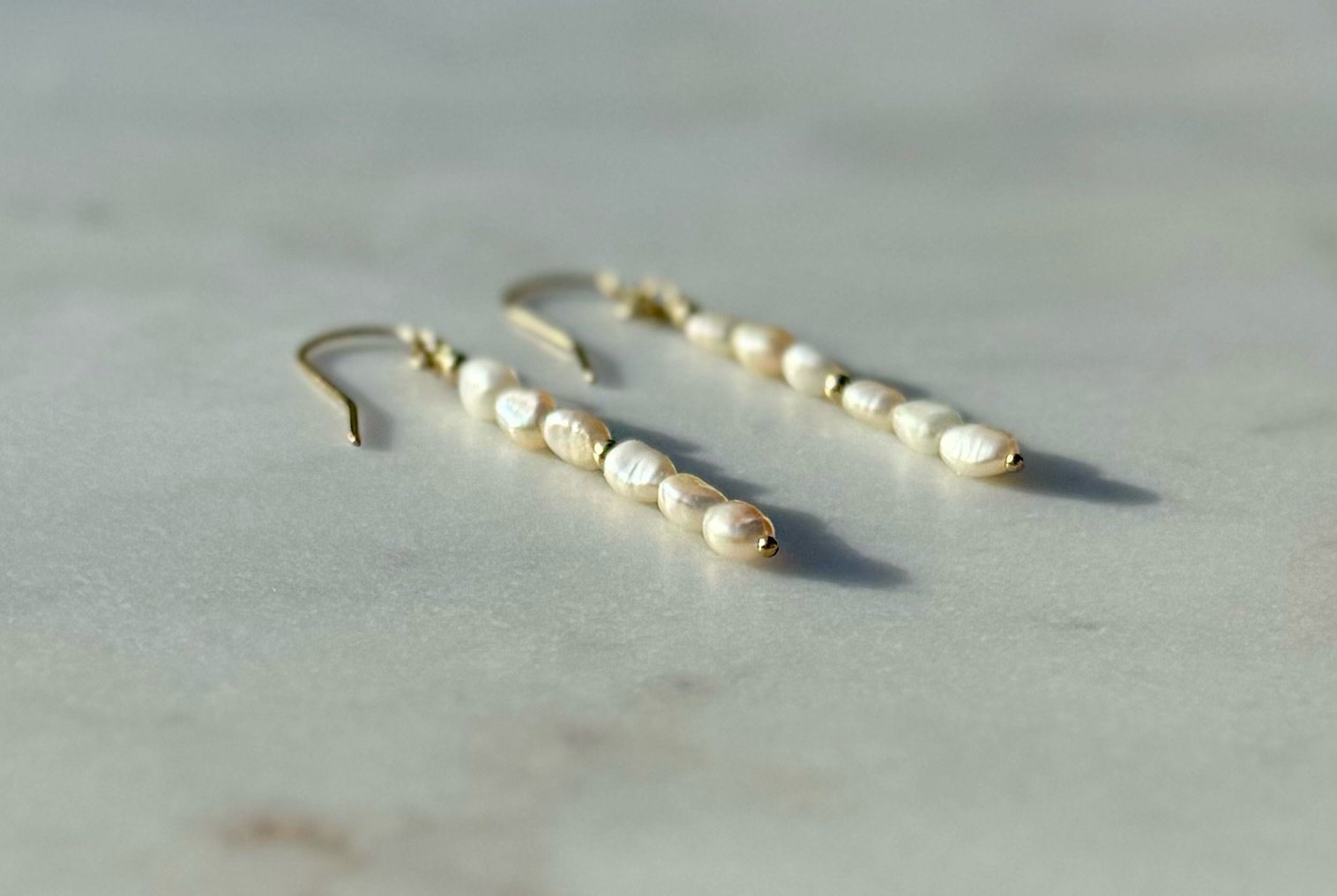 Meya Freshwater Baroque Seed Pearl Earrings On Surface.jpeg