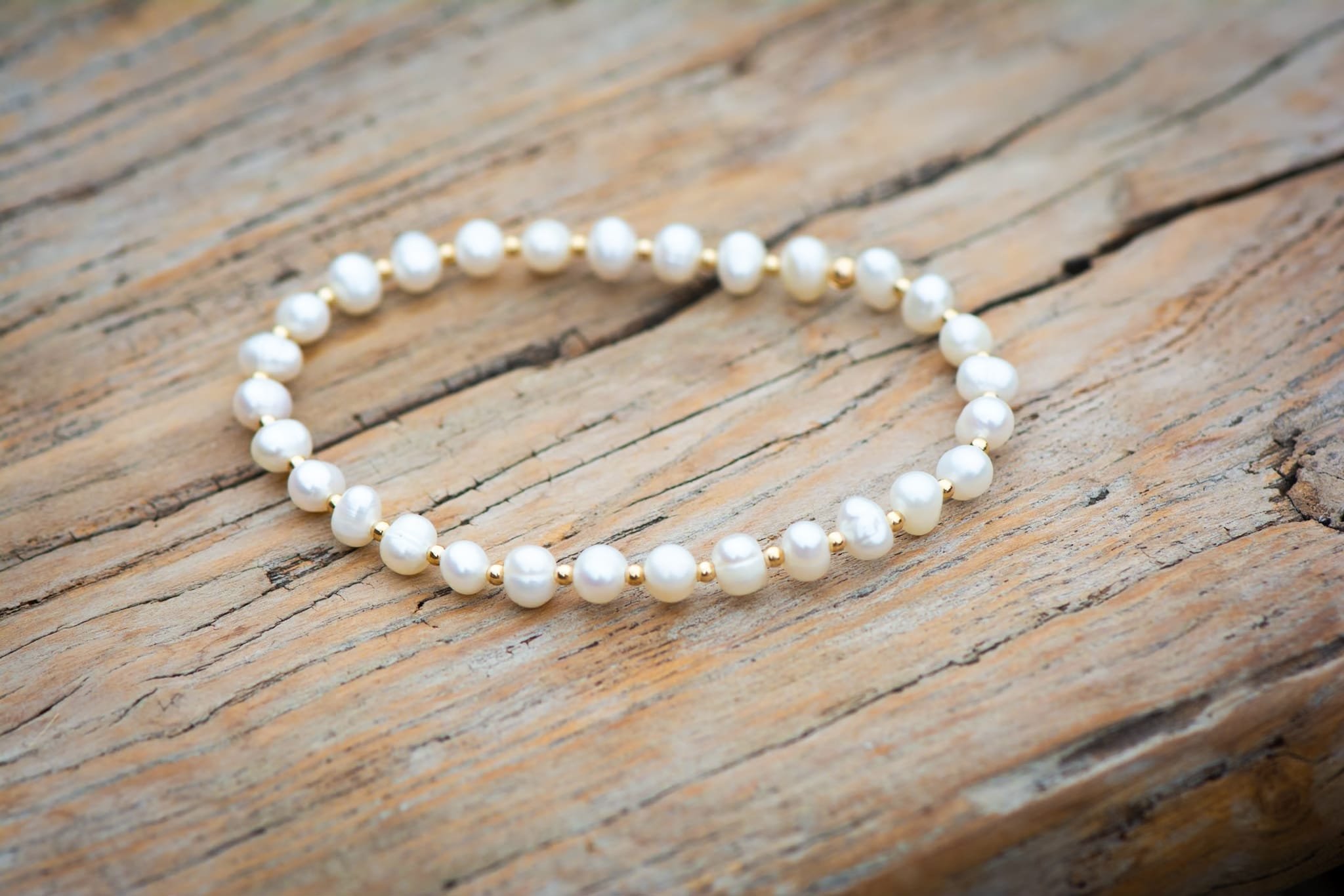 Lucinda Stretch Freshwater Potato Pearl Beaded Bracelet Wood Background.jpeg