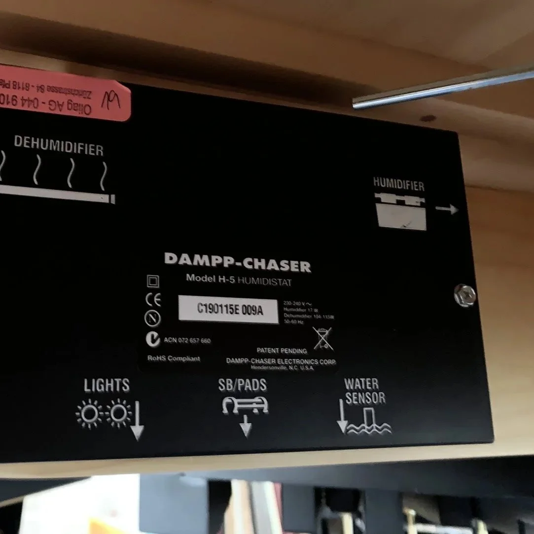 Panel eines Luftentfeuchters mit Kennzeichnungen für Lichter, Silikagel-Pads und Wassersensor.