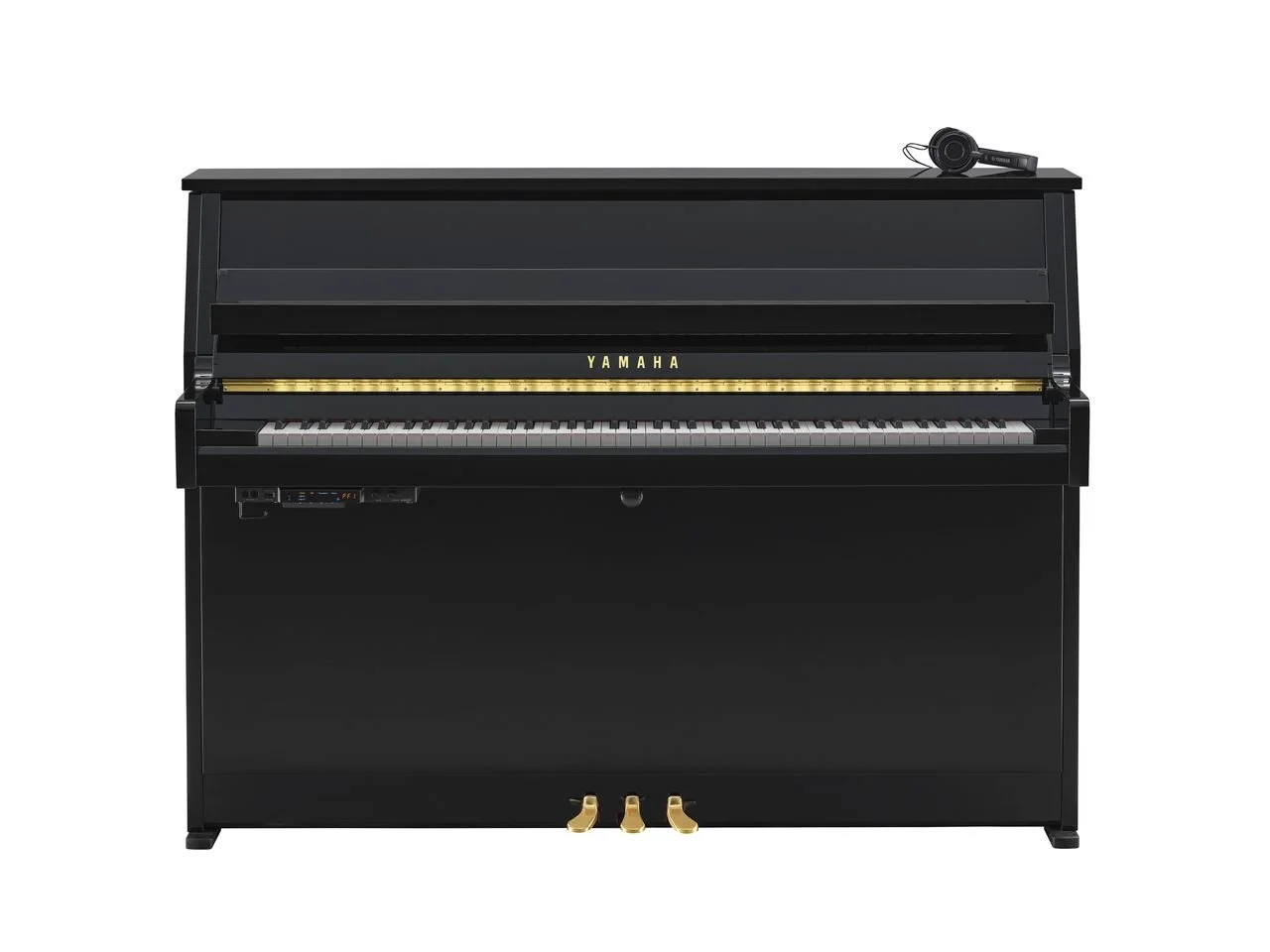 Ein schwarzes Klavier mit einer schwarzen Tastatur, einer goldfarbenen Stange über den Tasten, und einem Satz goldener Pedale. Auf dem Klavier liegt ein Paar Kopfhörer.