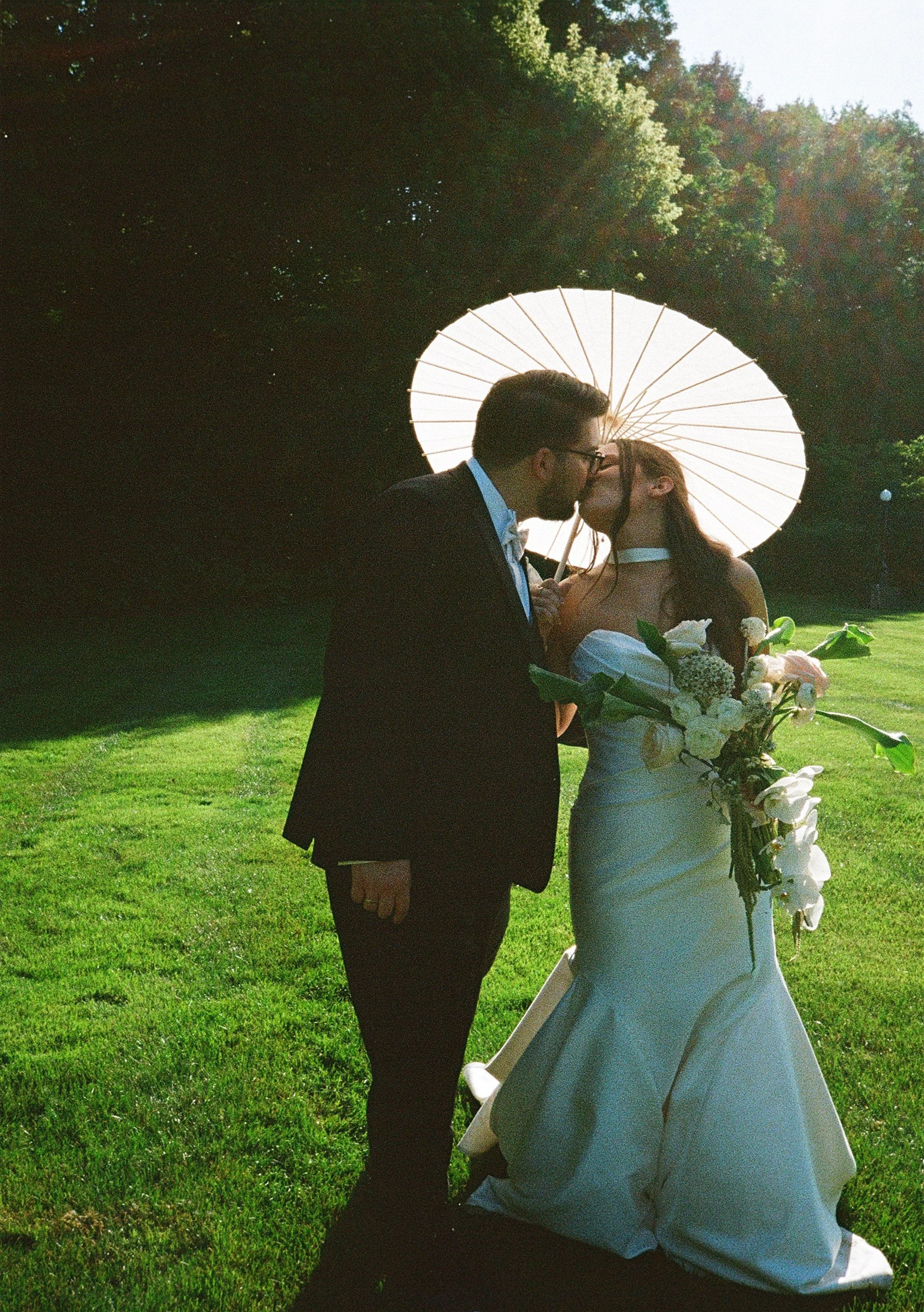 A film photo of a Bride + Groom on their wedding day kissing