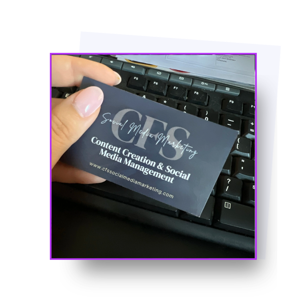 Business card for CF Social Media Marketing with focus on Content Creation & Social Media Management, held above a computer keyboard.