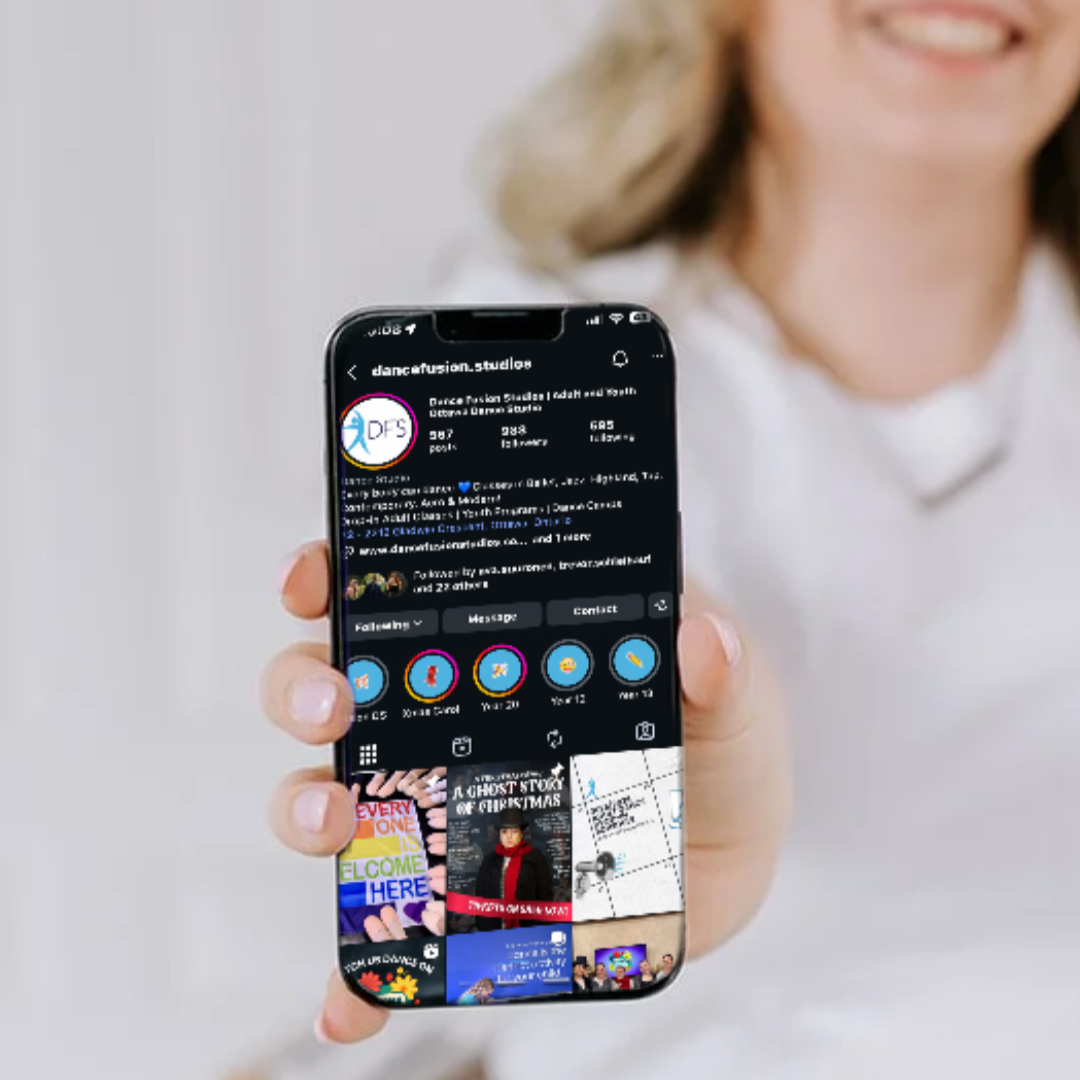Smiling woman holding smartphone showing an Instagram profile with colorful cover photos and profiles.