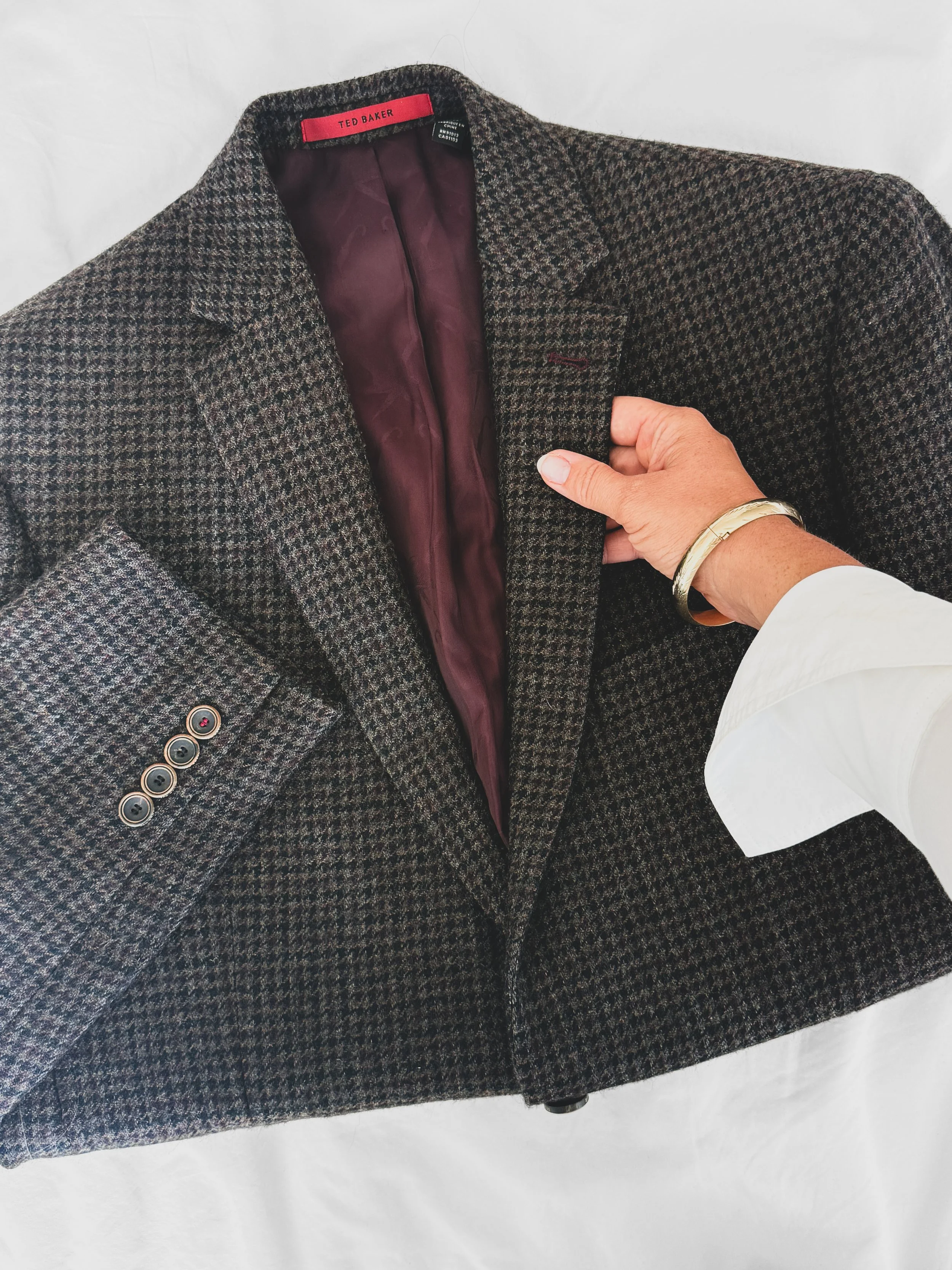 Men's personal stylist shopper touching the lapel of a wool blazer pair with a label for one on one styling, virtual or Chicago at Begin Anew