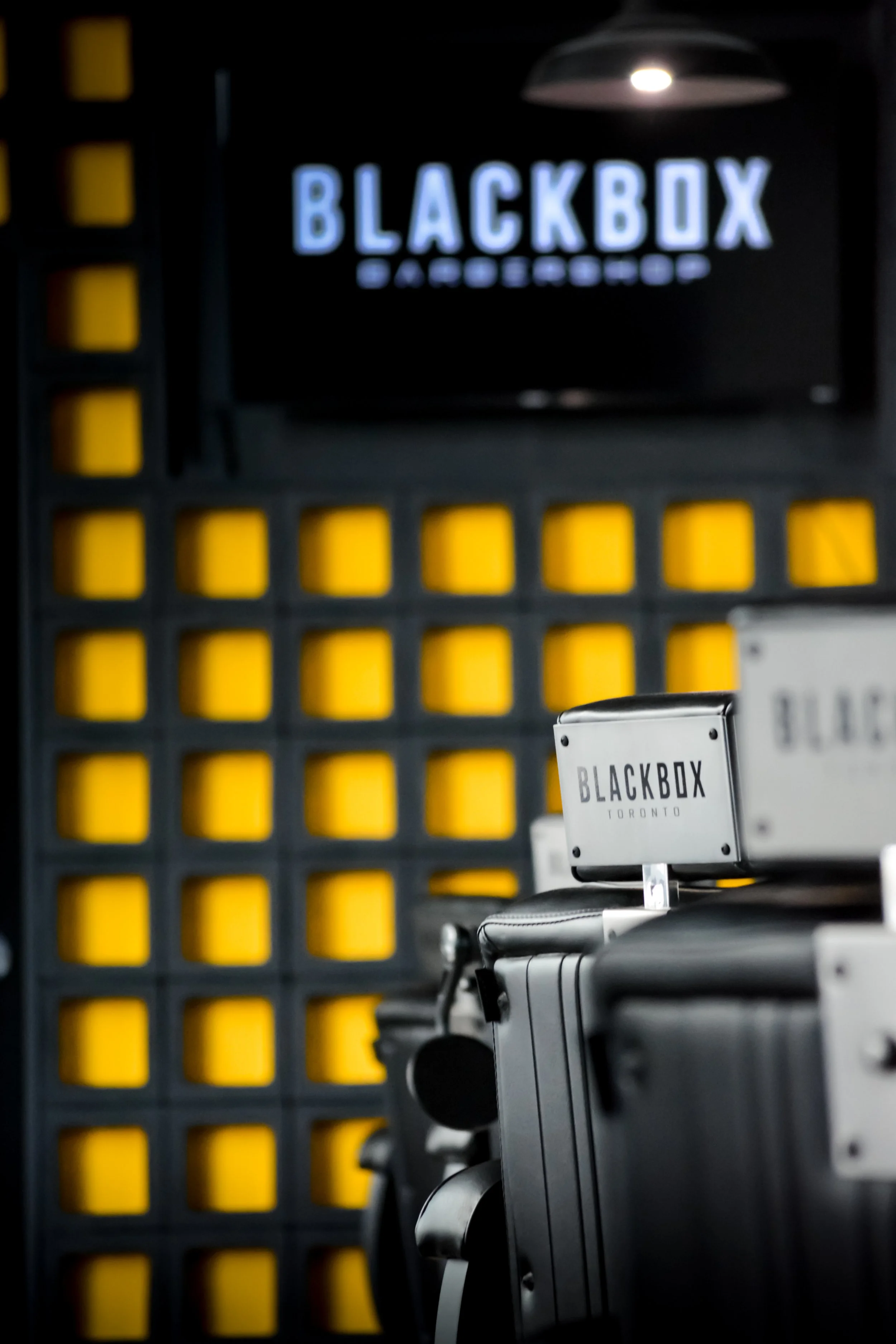 Photo of a gym or fitness studio with lockers and a sign for BlackBox Toronto, featuring gym equipment in the foreground and a display screen at the back.