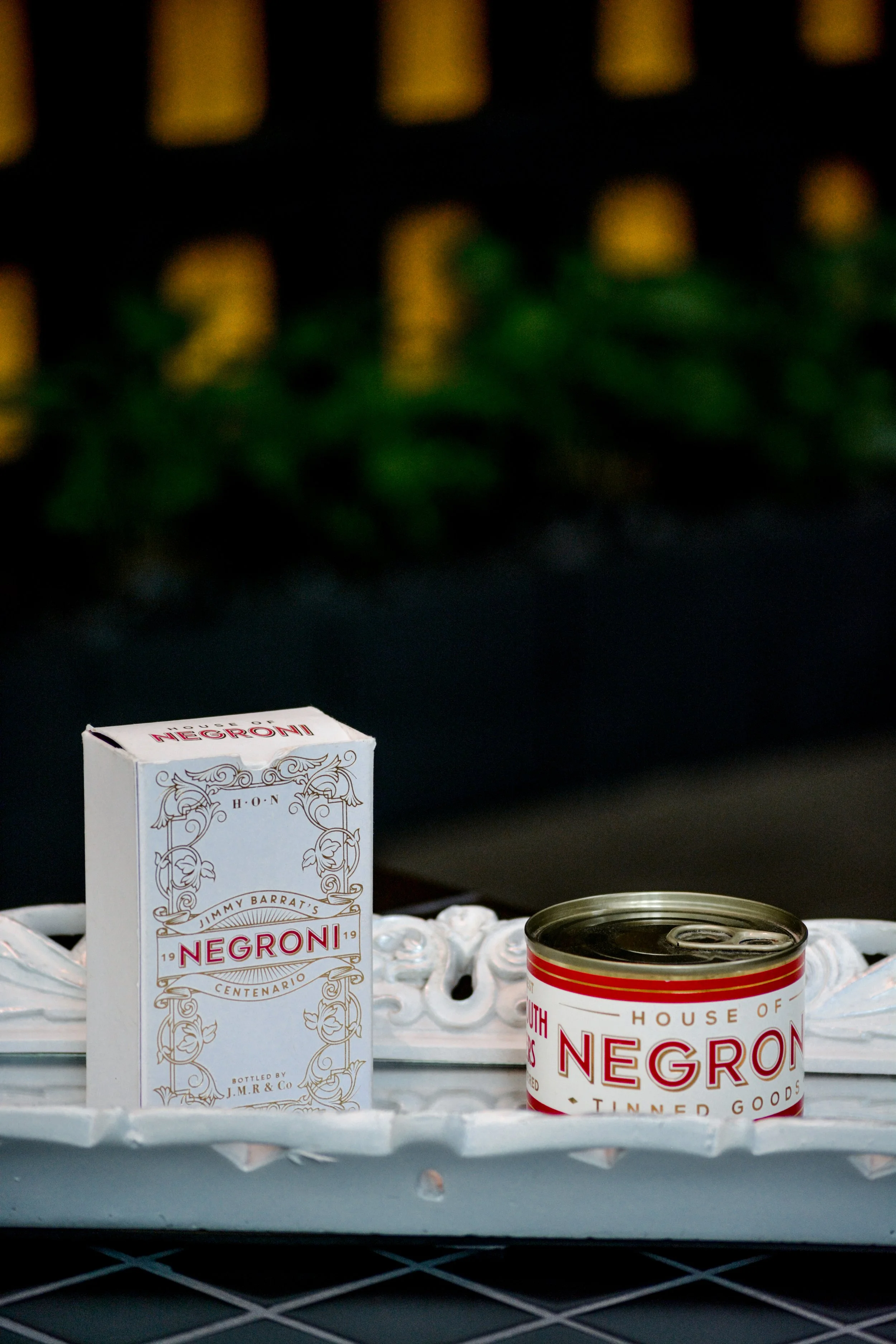 A box and a can of Negroni cocktail on a white decorative tray.