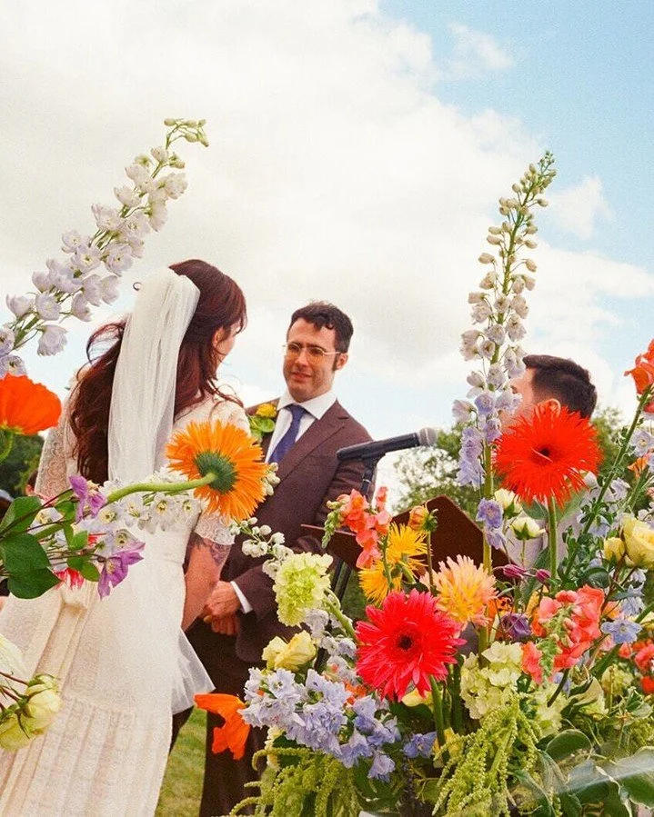 #WeddingWednesday: Becca and Wyatt's lakeside wedding at Independence Grove was a mix of fun flowers and punchy colors. From feathered gerberas to neon poppies to wildflowers like clematis and lisianthus, their funky, eclectic bouquets paid homage to
