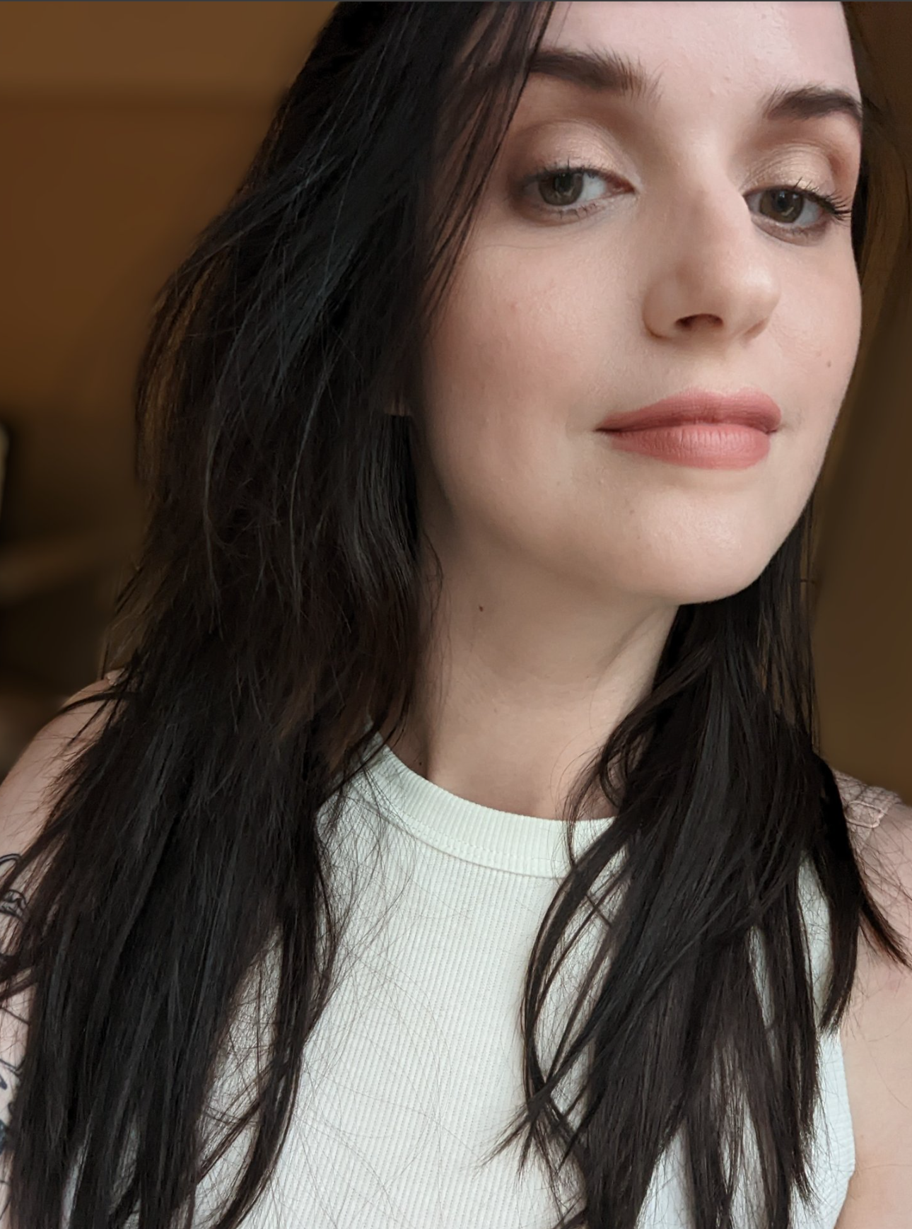 Dee is a white woman with long dark hair and wearing a white top.
