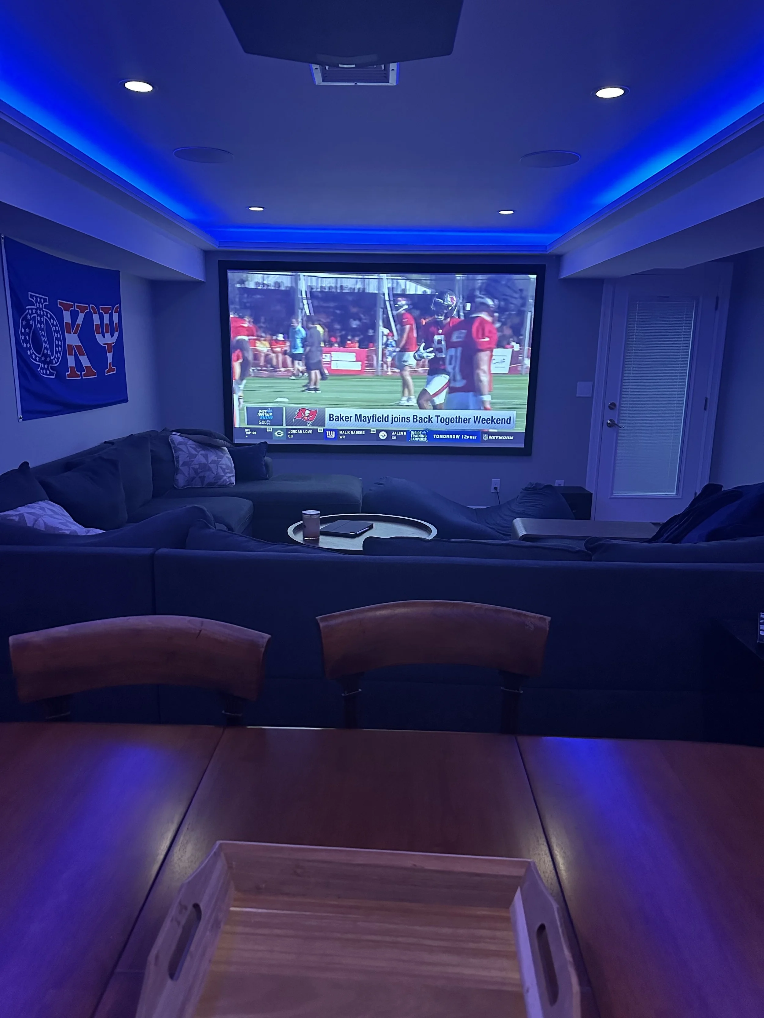 Home Theater with a 110" screen displaying a football game with dolby atomos surround sound