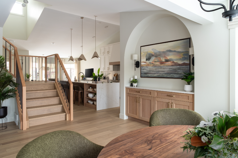 Modern house interior with a wooden staircase leading to an open-plan kitchen and living area.
