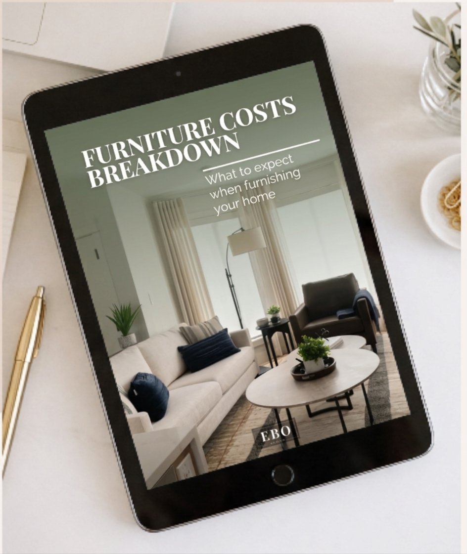 A black tablet lying on a desk next to a gold pen, displaying the cover of an interior design guide titled 'Furniture Costs Breakdown: What to expect when furnishing your home'.