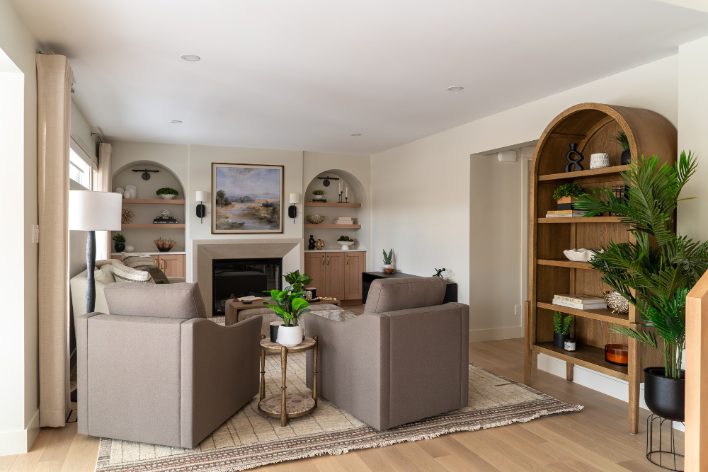 Spacious modern living room with a central concrete fireplace and built-in arched shelves.