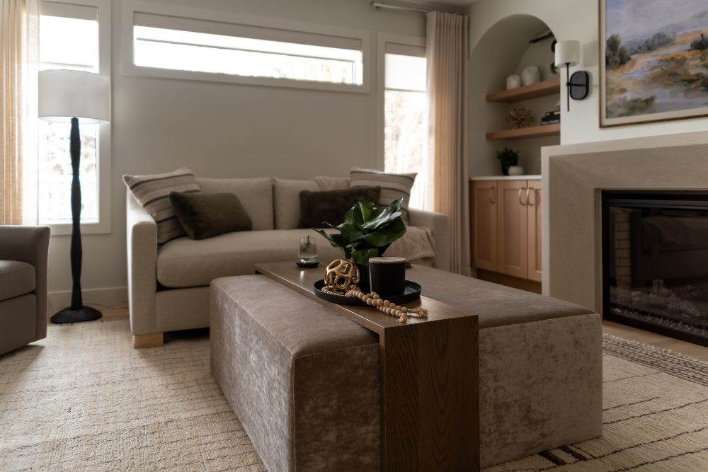 A cozy living room scene showcasing a velvet storage ottoman used as a coffee table, a light-colored sofa, and a modern fireplace with built-in shelving.
