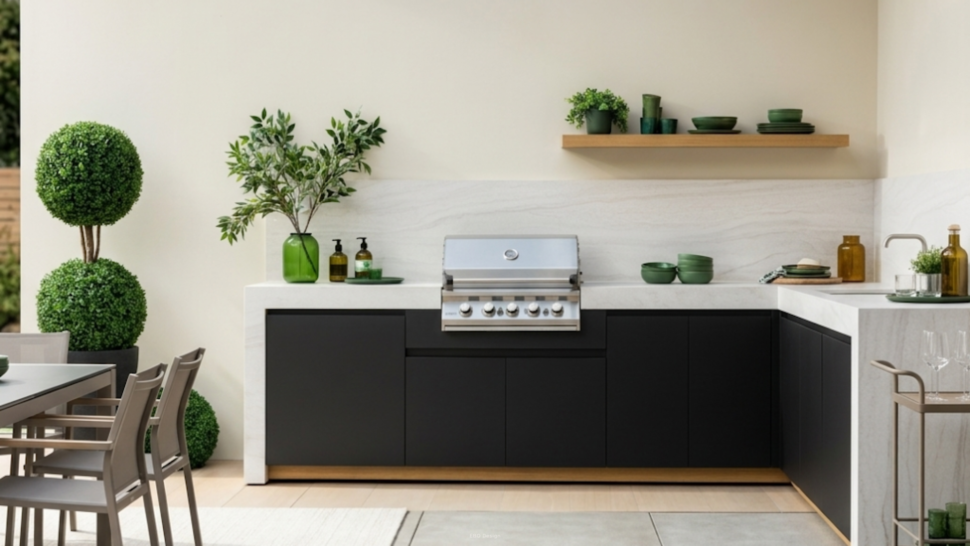 Sleek modern outdoor kitchen featuring matte black cabinetry, a white waterfall countertop, and a built-in stainless steel grill.