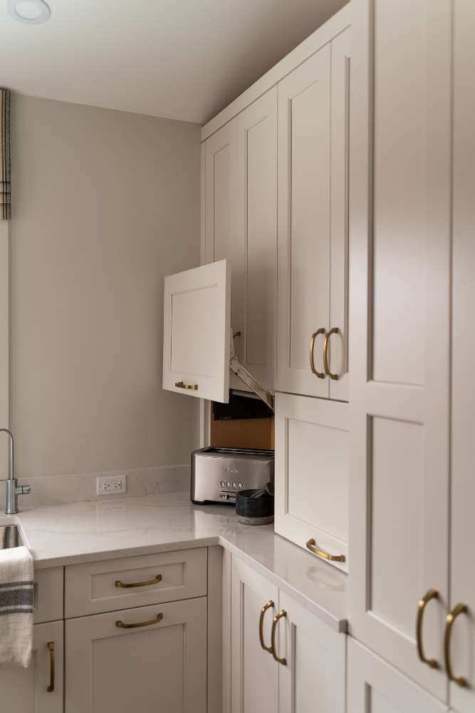 A detailed close-up shot of a mechanical lift-up hinge system for a kitchen cabinet, showing it in the open position.