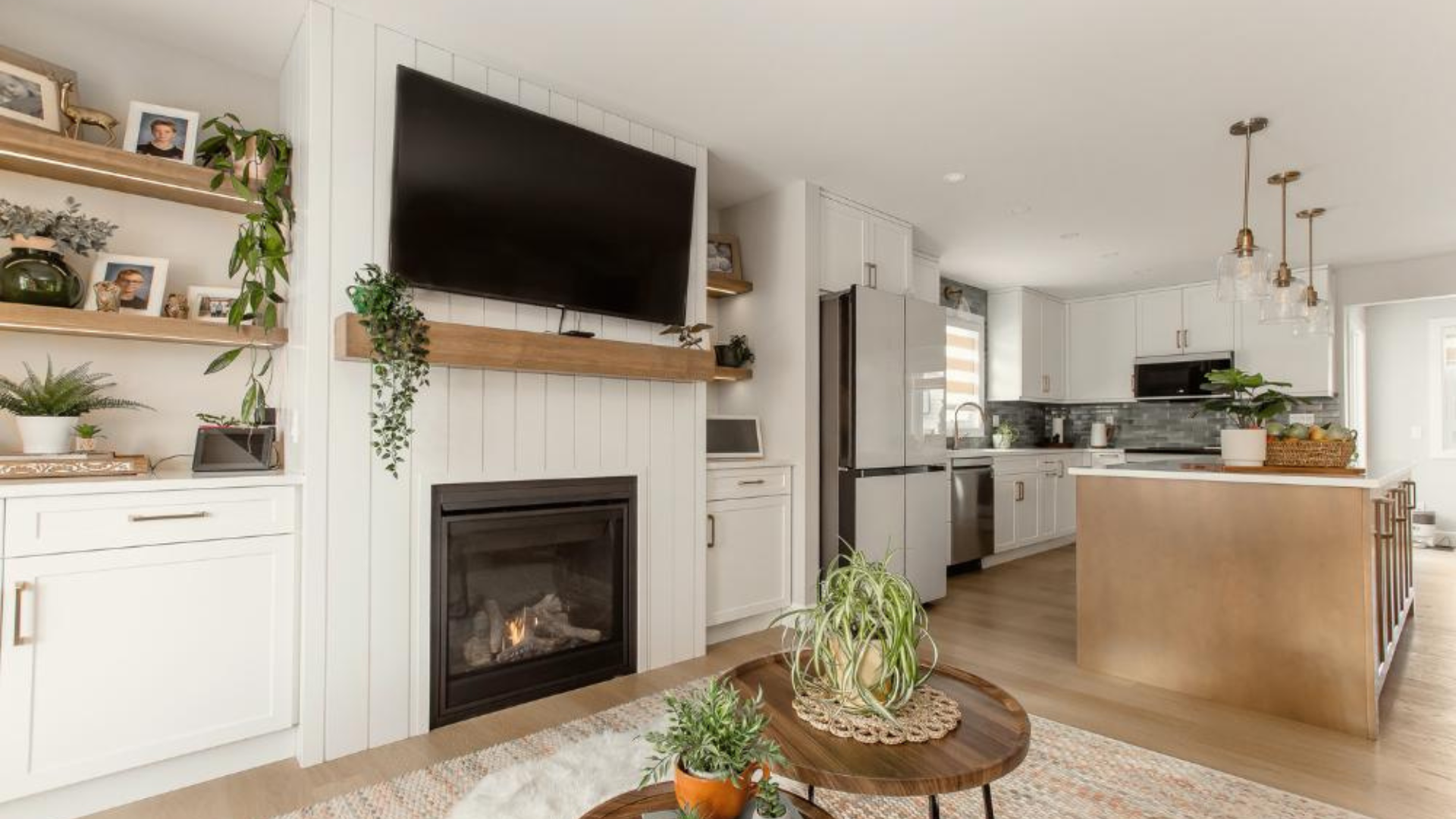 Open-concept living room and kitchen with neutral finishes, natural wood, and simple styling that reflects a timeless interior design approach over short-lived trends.