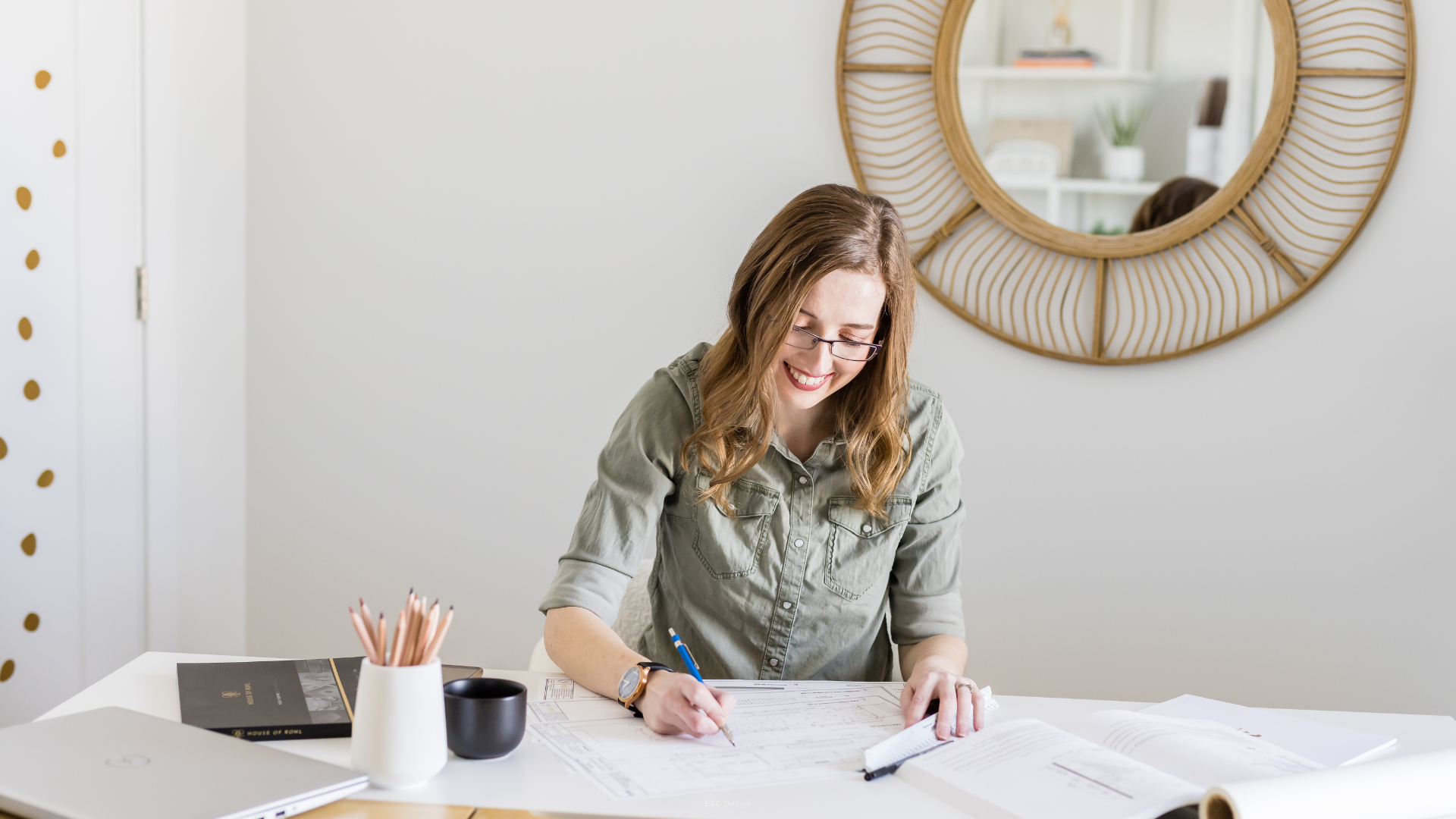 A professional Edmonton interior designer reviewing construction blueprints and renovation budget plans.