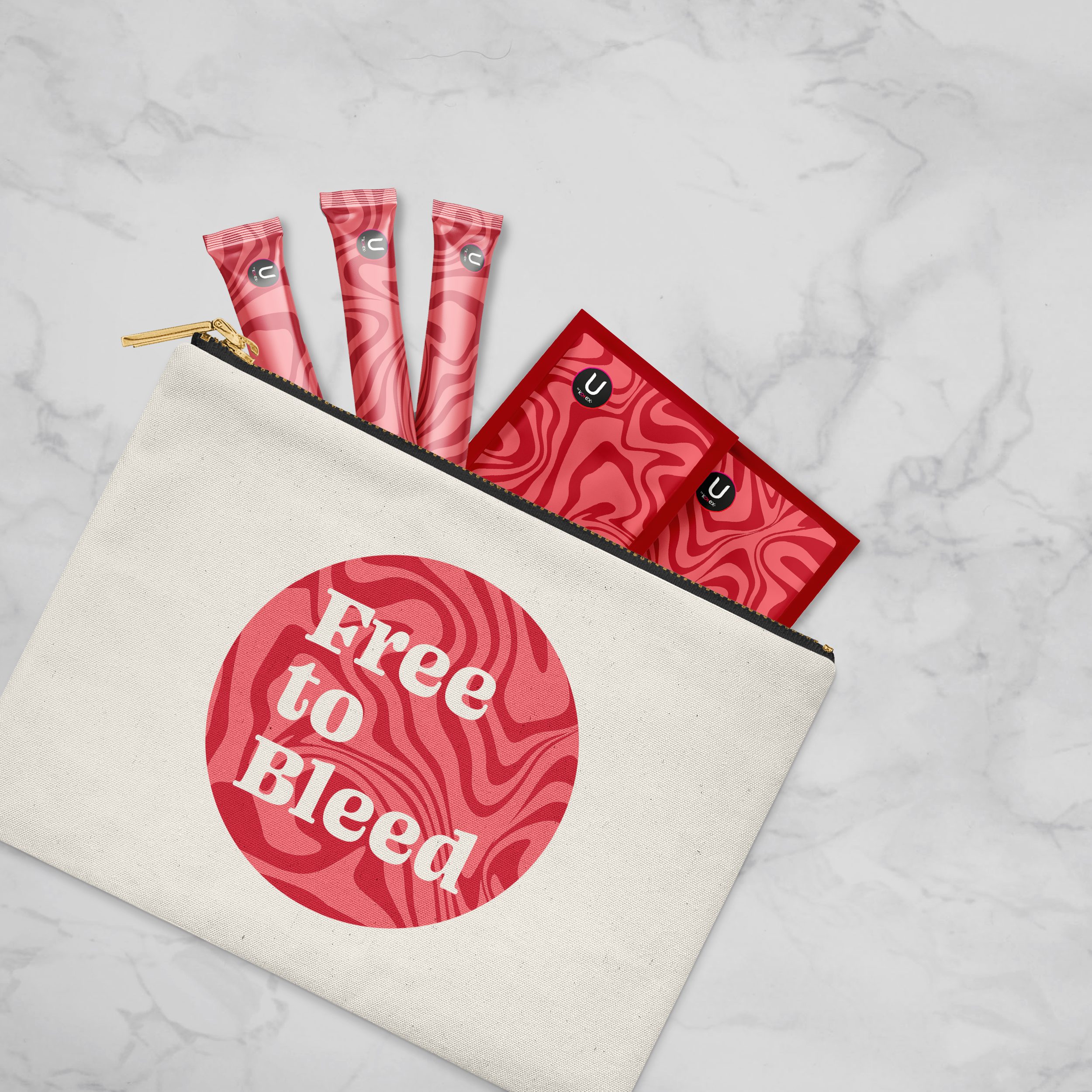 Canvas zipper pouch on a marble surface with a pink and red marbled circle reading “Free to Bleed” on the front, partially open to reveal pink patterned tampon wrappers and red pad packets inside.