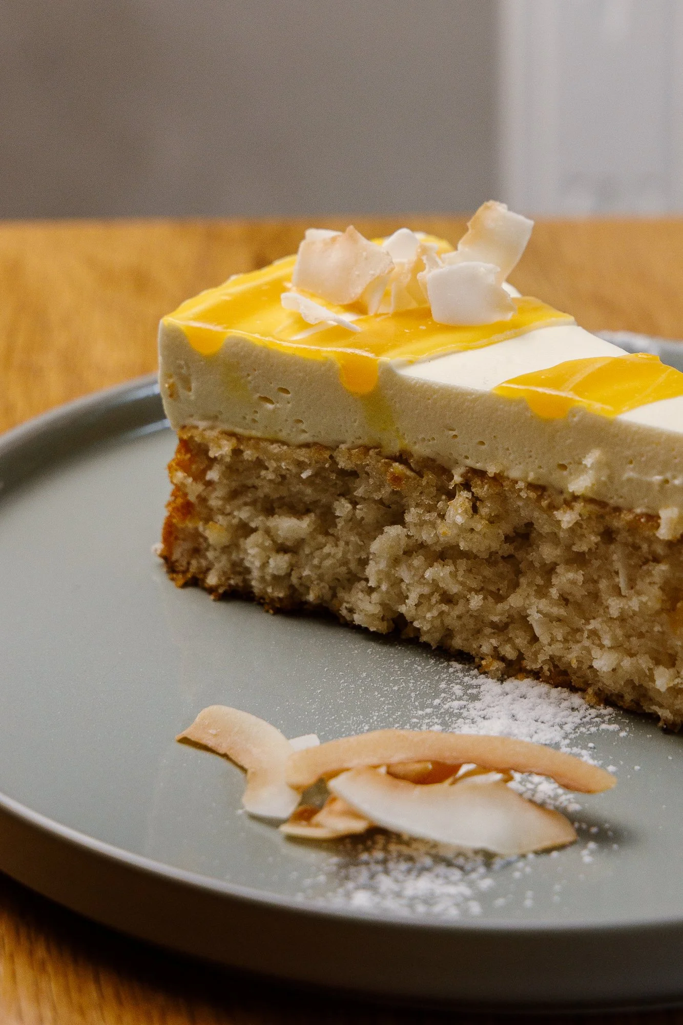 Käsekuchen mit weißen Schokoladenstückchen auf einem grauen Teller