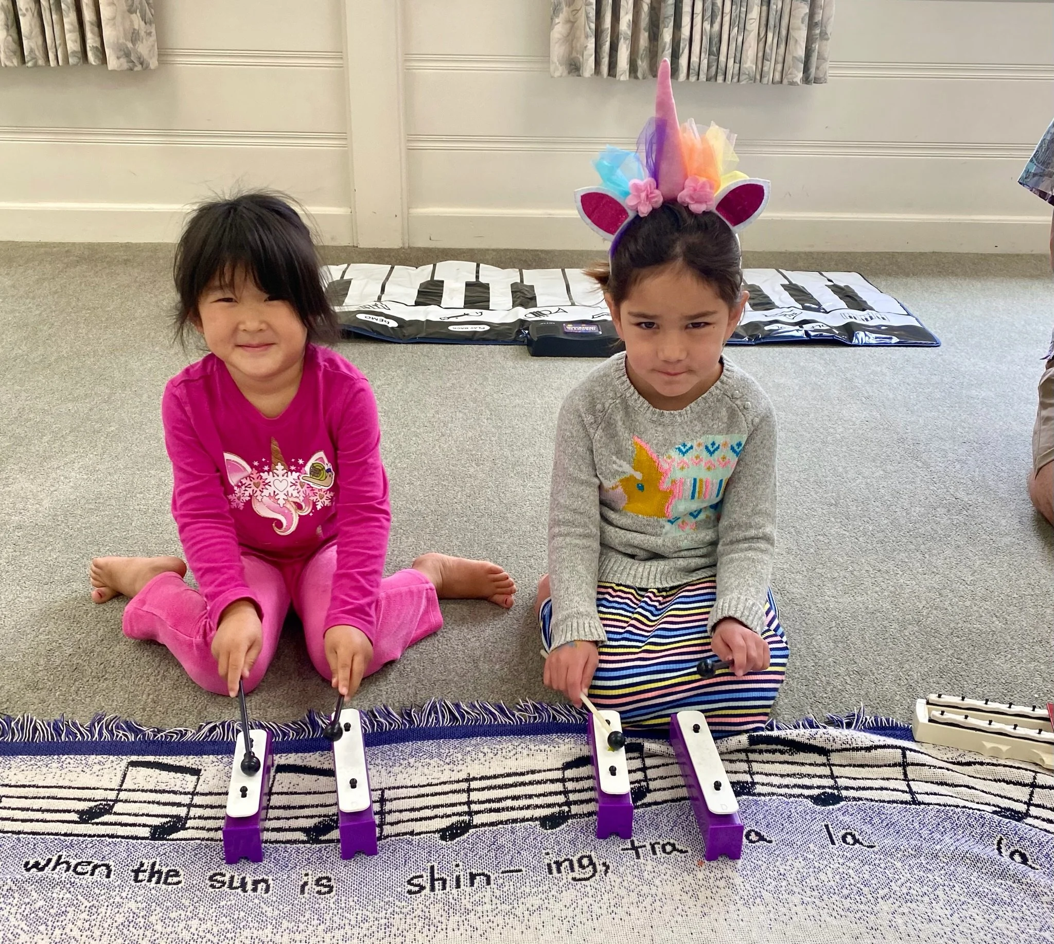 Two girls learning the xylophone, glockenspiel and piano at Kathys music and movement in Santa Barbara
