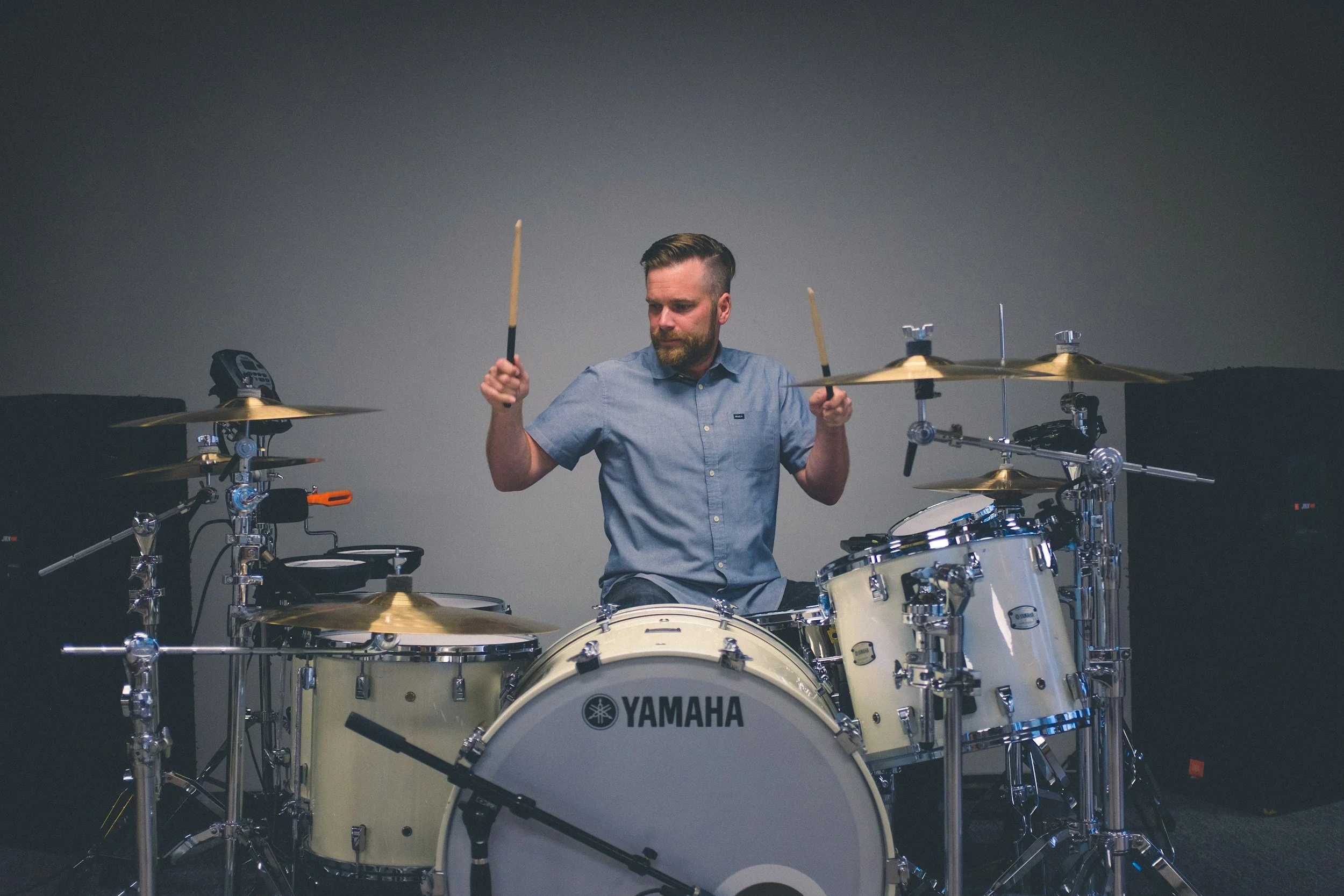 A man playing a Yamaha drum set with multiple cymbals, drums, and electronic pads.