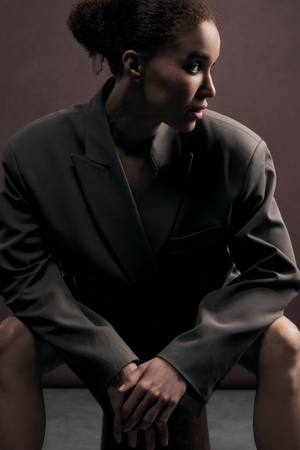 Fashion photography of a woman in grey blazer looking to the side. 