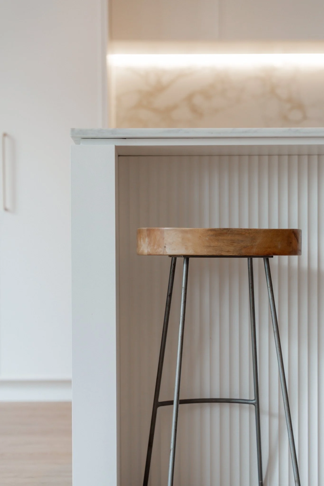 Folded Polytec Thermolaminated end panels in Classic White, Feature Cove panelling, Lavistone Eleganto Gold Benchtops and Splashbacks & Lux Handles Curved Brass  