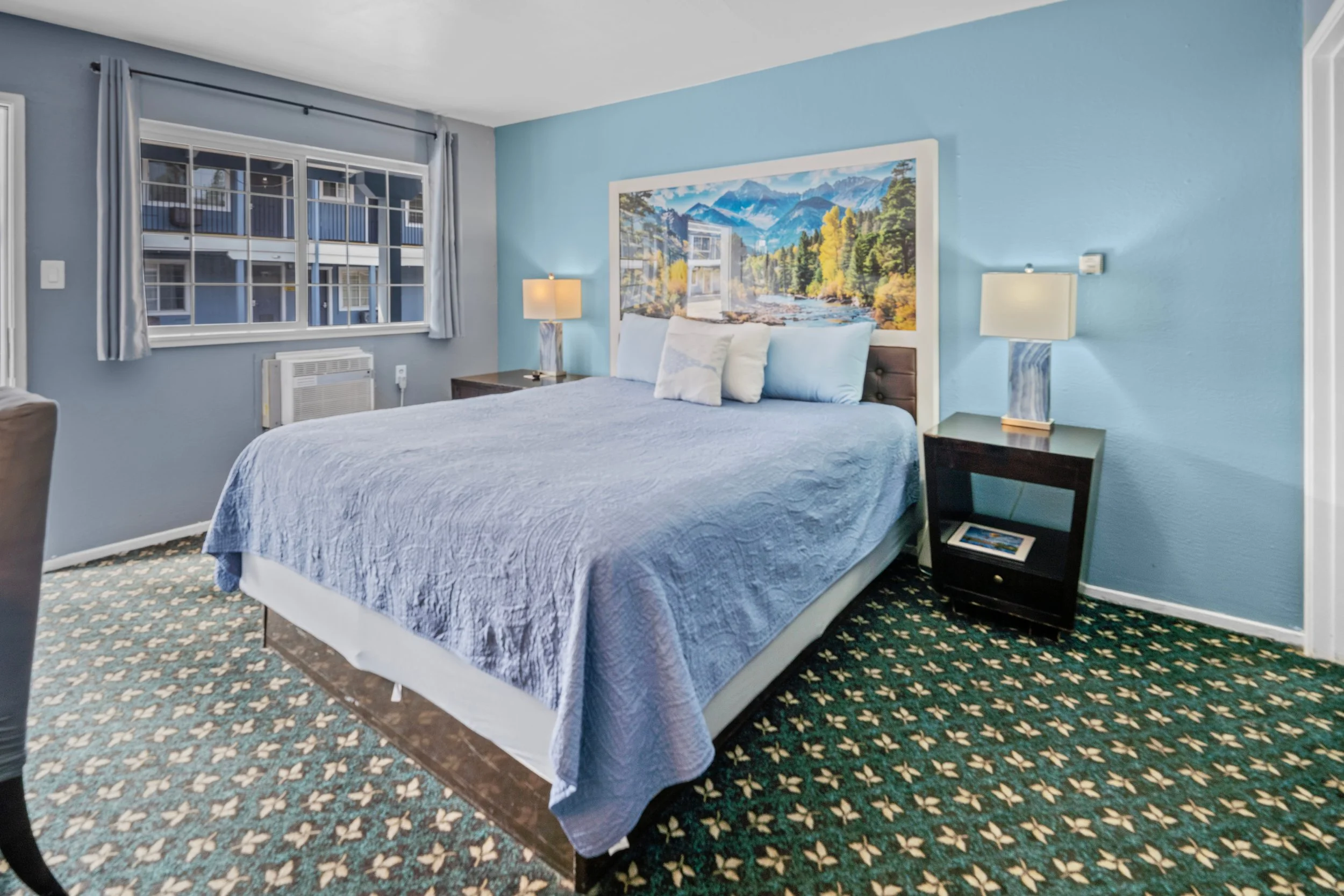 Queen room at Bluebird Day Inn & Suites in South Lake Tahoe near Heavenly Mountain Resort with mountain artwork and mini fridge