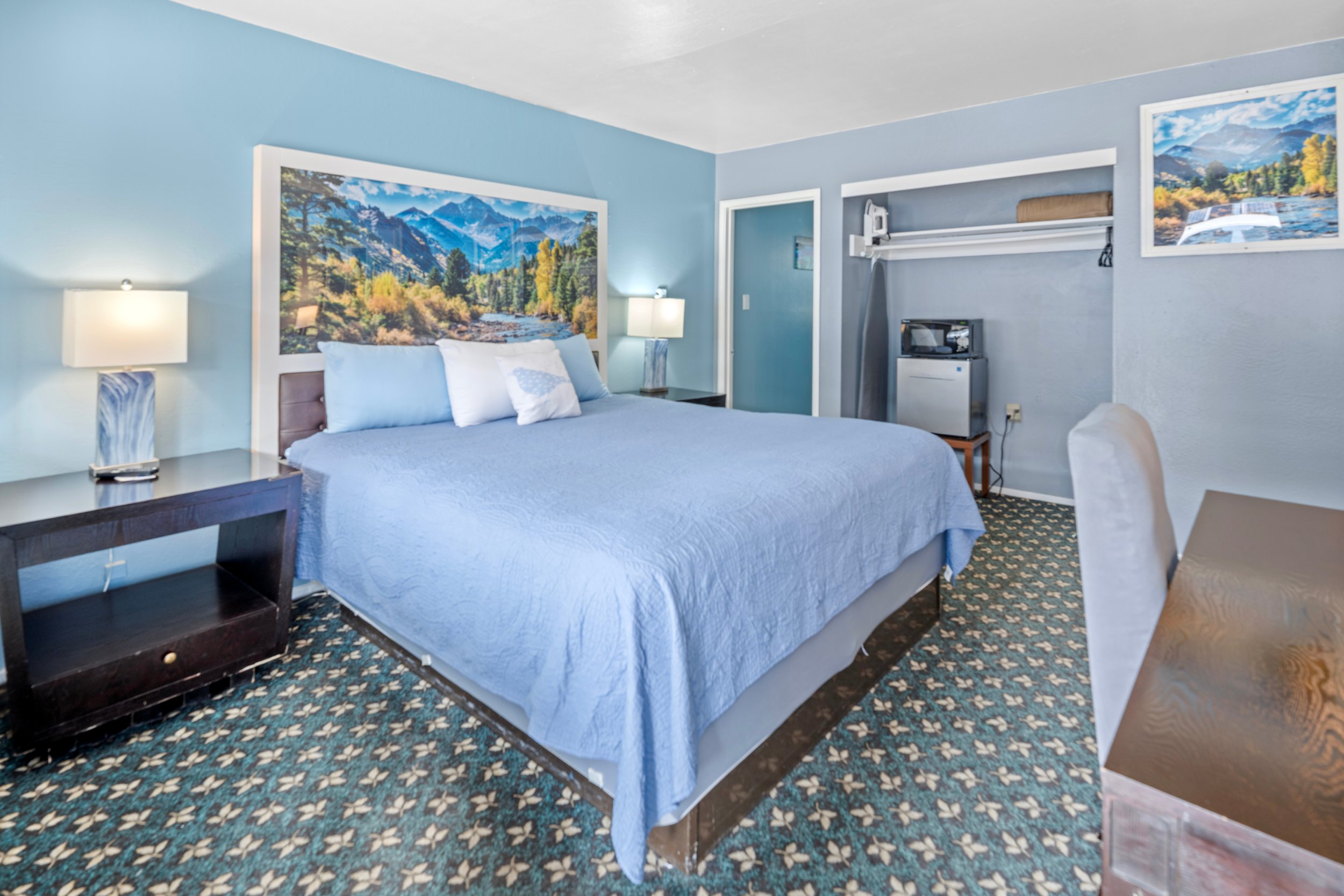 Modern king room at Bluebird Day Inn & Suites in South Lake Tahoe near Heavenly Mountain Resort with mountain artwork and mini fridge