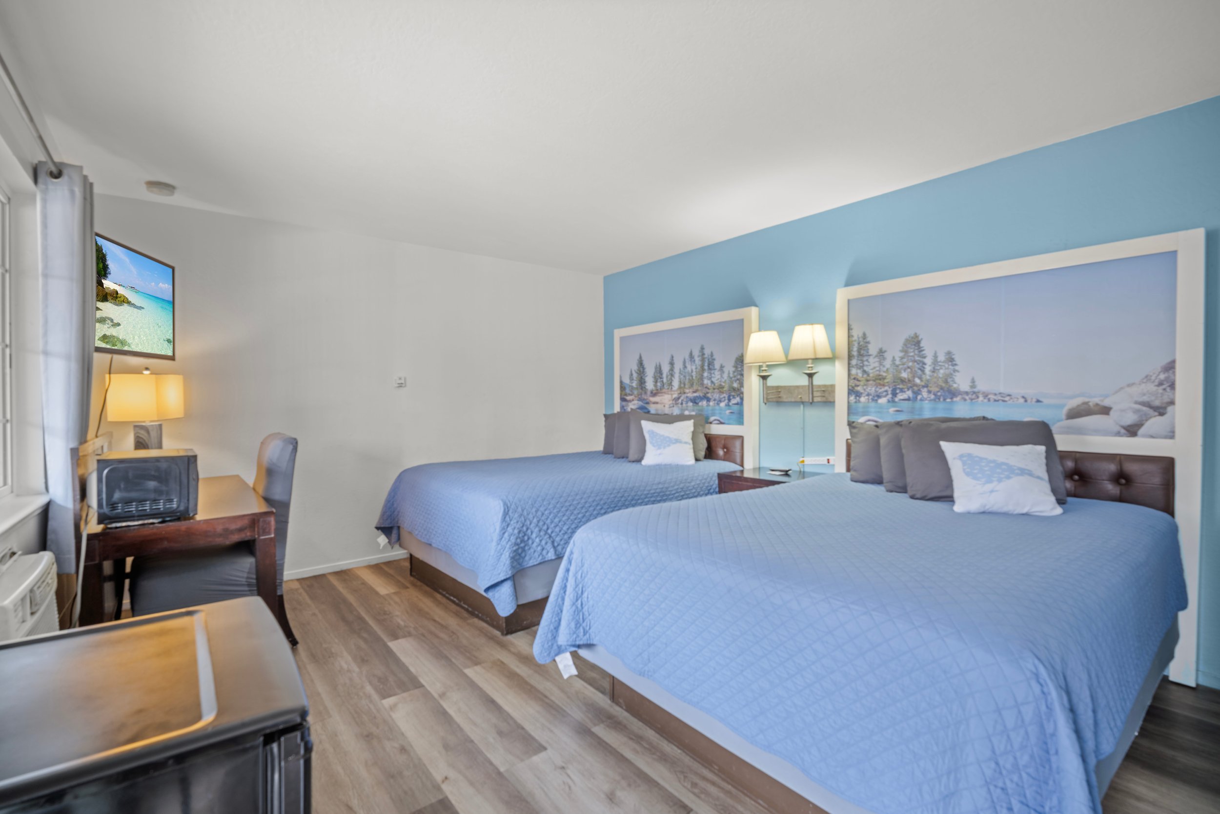 Double Queen room at Bluebird Day Inn & Suites in South Lake Tahoe near Heavenly Mountain Resort with mountain artwork and mini fridge
