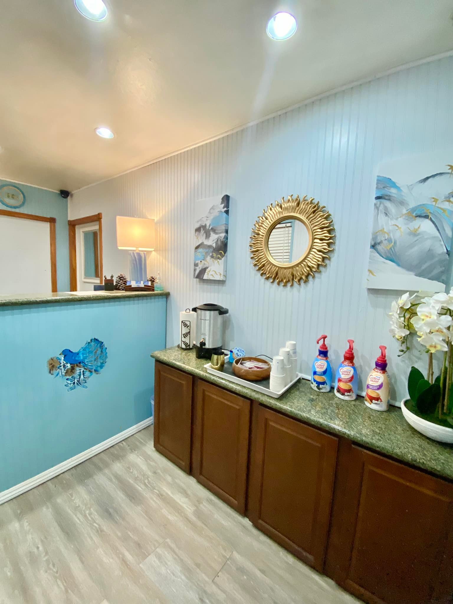Bluebird Day Inn & Suites office with a coffee station, and wall art welcoming guests.