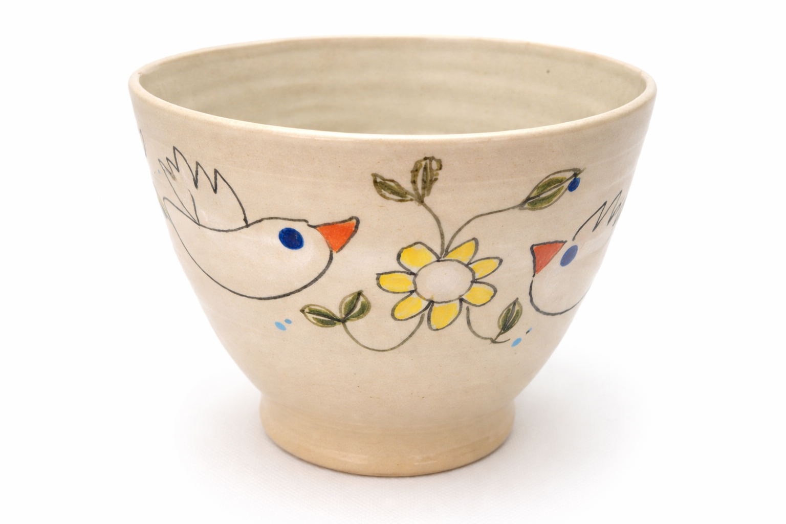 Un bol en céramique décoré de dessins de deux oiseaux, une fleur jaune et des feuilles vertes.