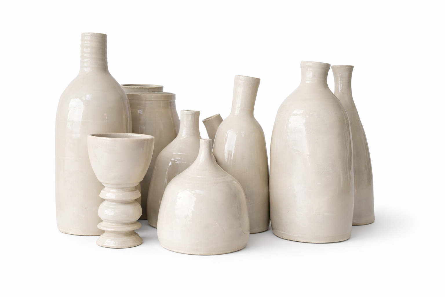Collection de plusieurs vases en céramique blanche de différentes formes et tailles sur un fond blanc.