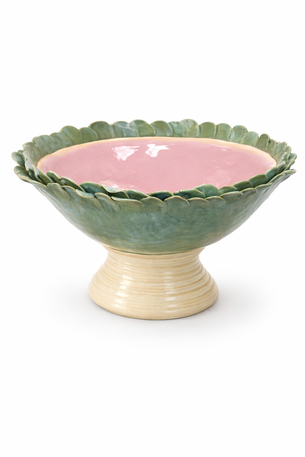 Un bol en céramique avec un intérieur rose et un rebord décoratif en forme de feuilles vertes, posé sur une base beige.