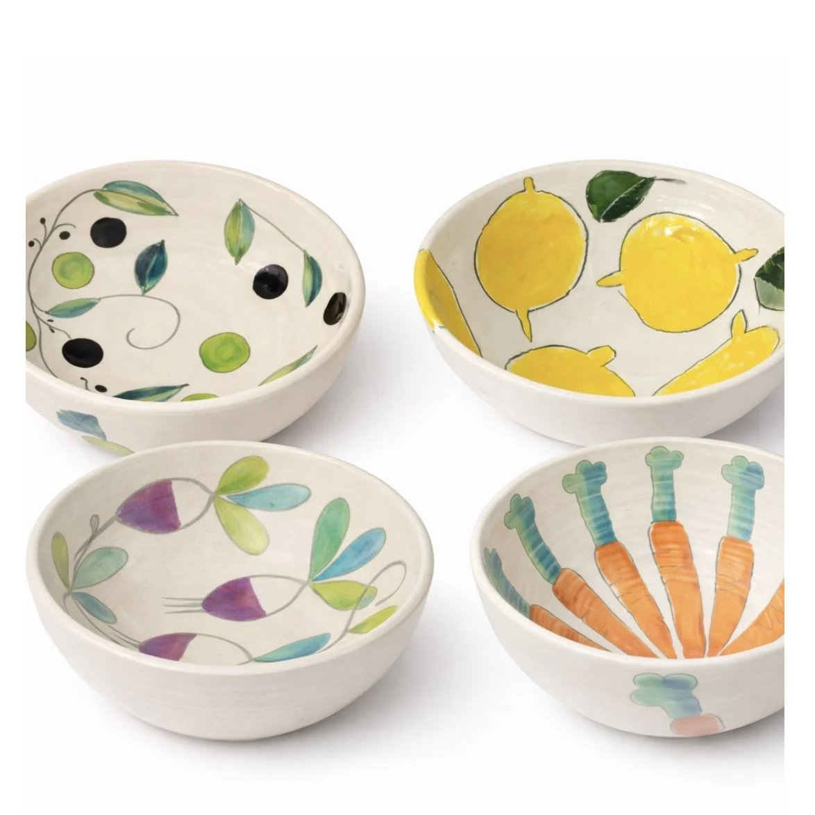 Quatre petits bols en céramique décorés de motifs colorés, dont des fruits et des légumes.