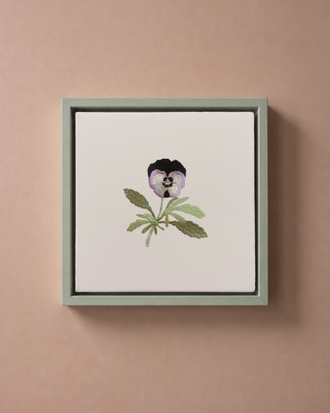 Violet February birth flower canvas featuring botanical embroidery in a sage green frame.