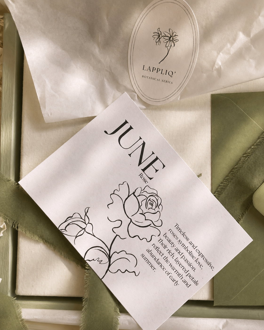 June birth meaning card alongside luxury gift packaging for the Botanical Birth Flower Collection, featuring  sage green ribbon.