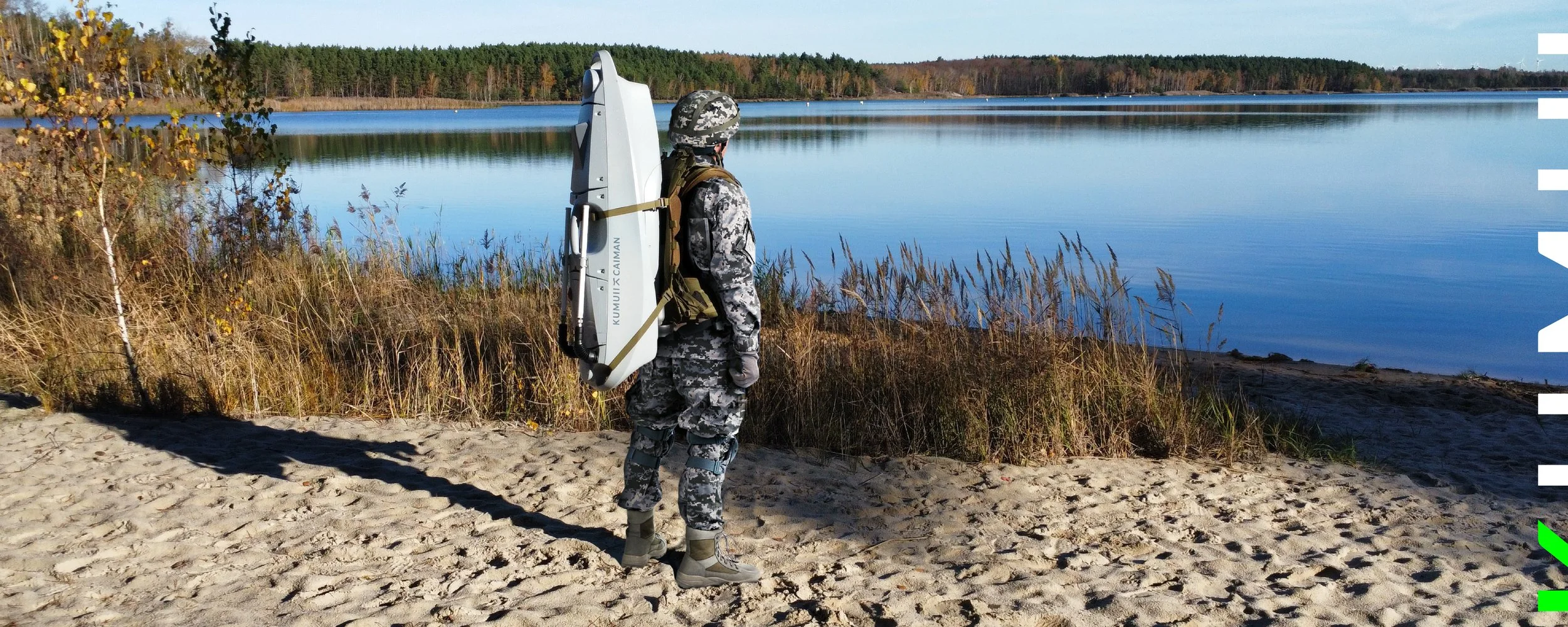 Soldat steht am Ufer eines Sees mit einem kumuii Caiman