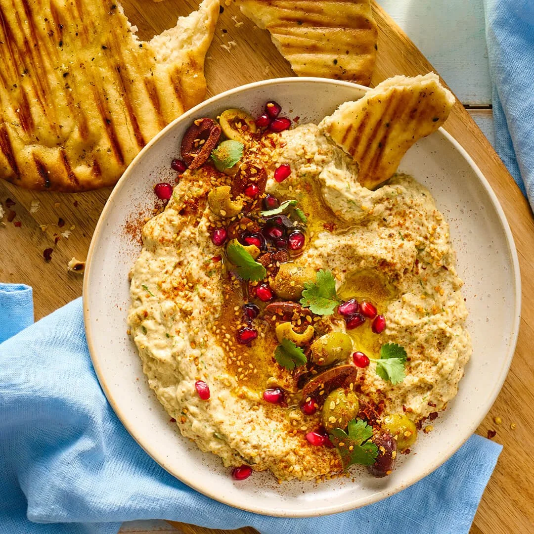 Bord met baba ganoush met gegrild naanbrood erbij