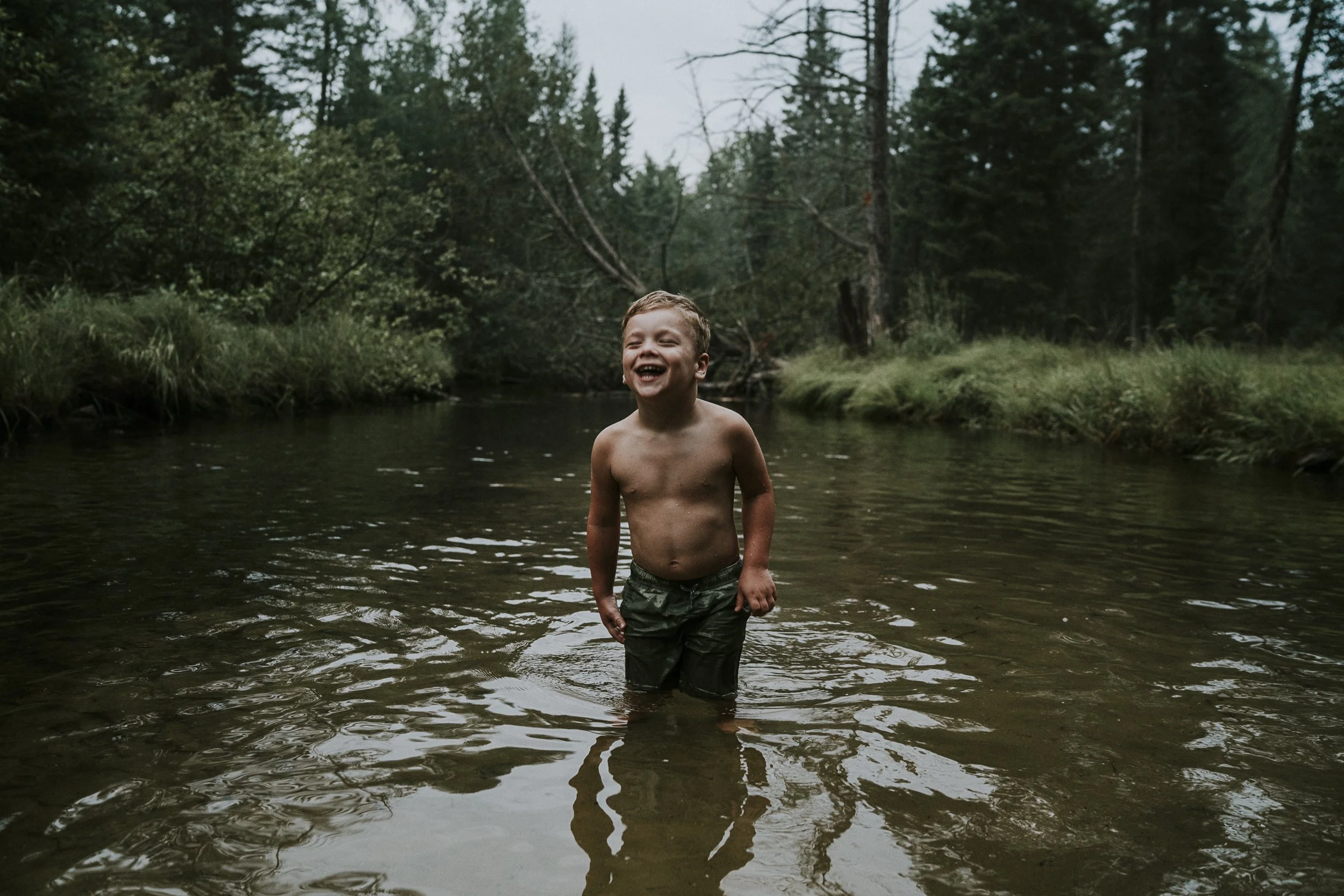 kid laughing in the river