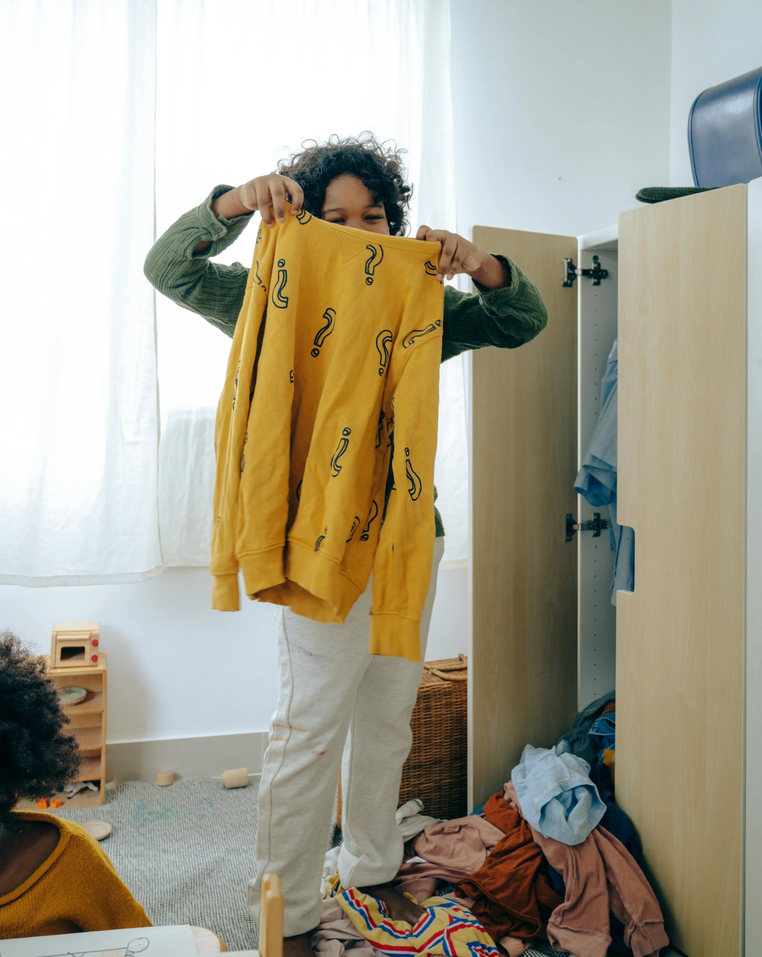 Child folding his jumper.jpg