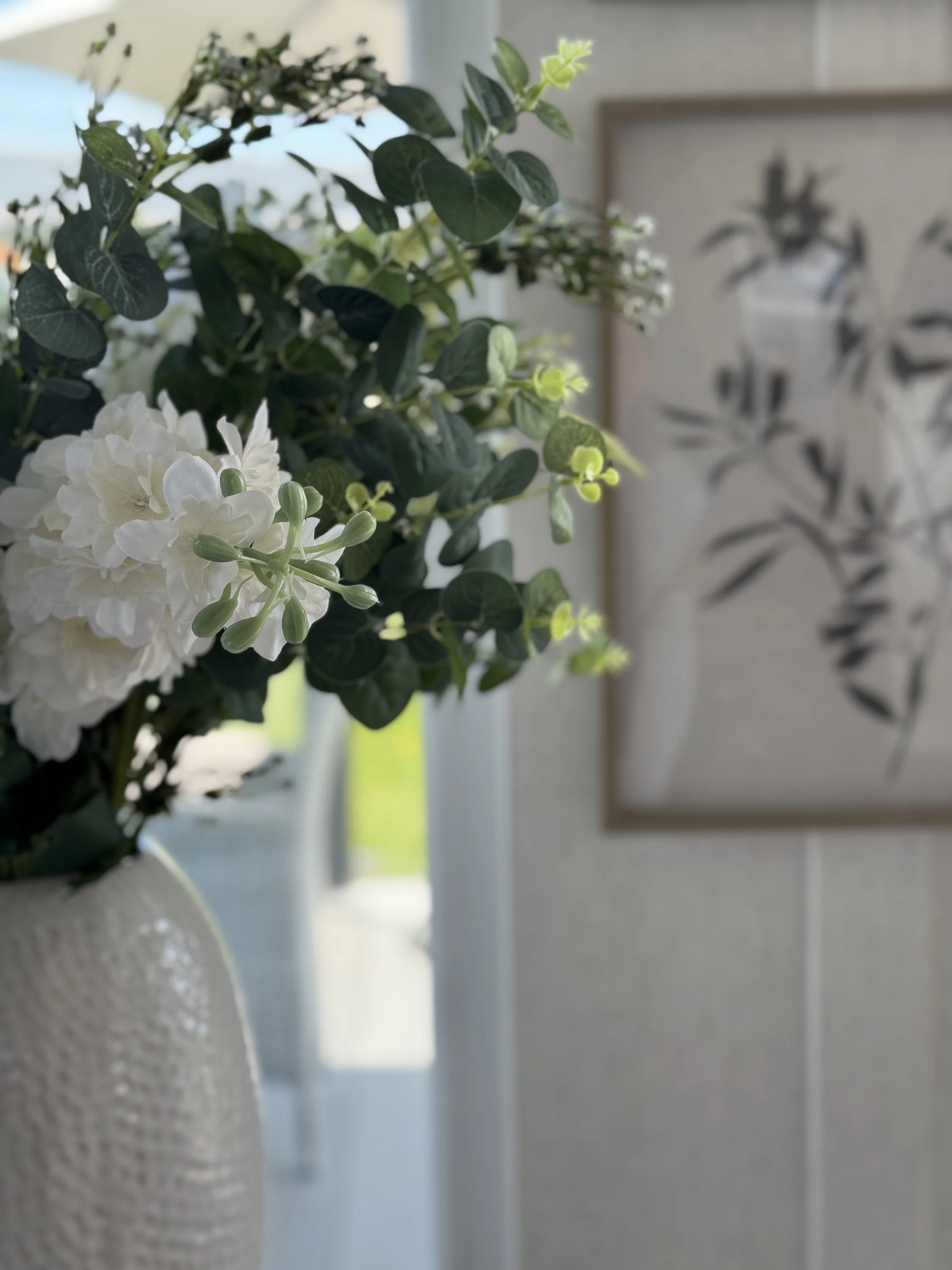 Magazine page with three photos related to home organization and decor, featuring a person arranging items, a hand opening a kitchen drawer, and a drawer with neatly organized cutlery.