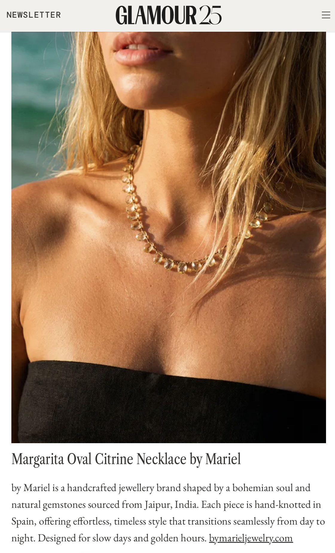 Close-up of a woman wearing a gold and gemstone necklace made of citrine, with sun-kissed skin, blonde hair, and a black strapless top, taken outdoors with a blurred background.