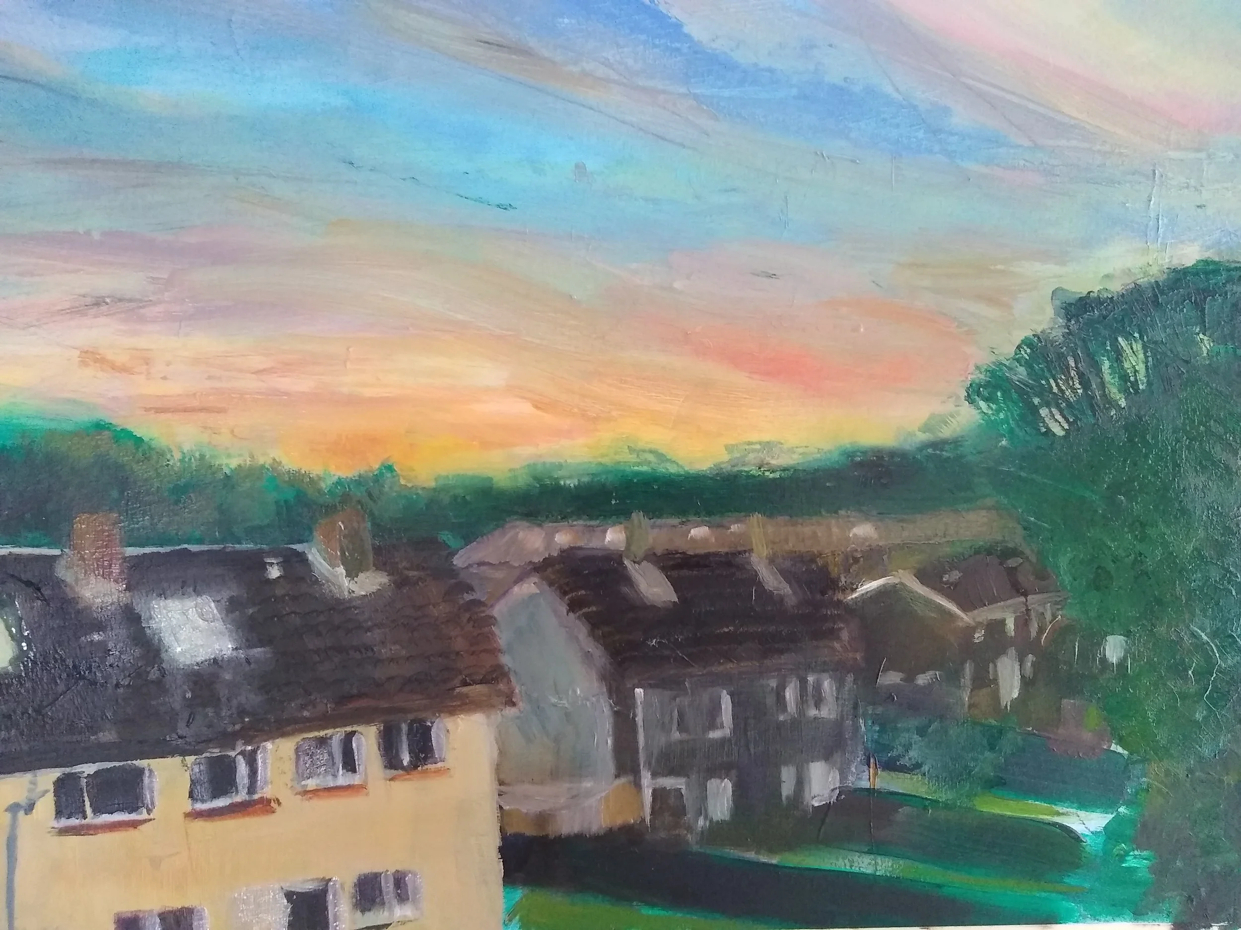 A watercolor painting of a small town at sunset with houses, trees, and colorful sky.