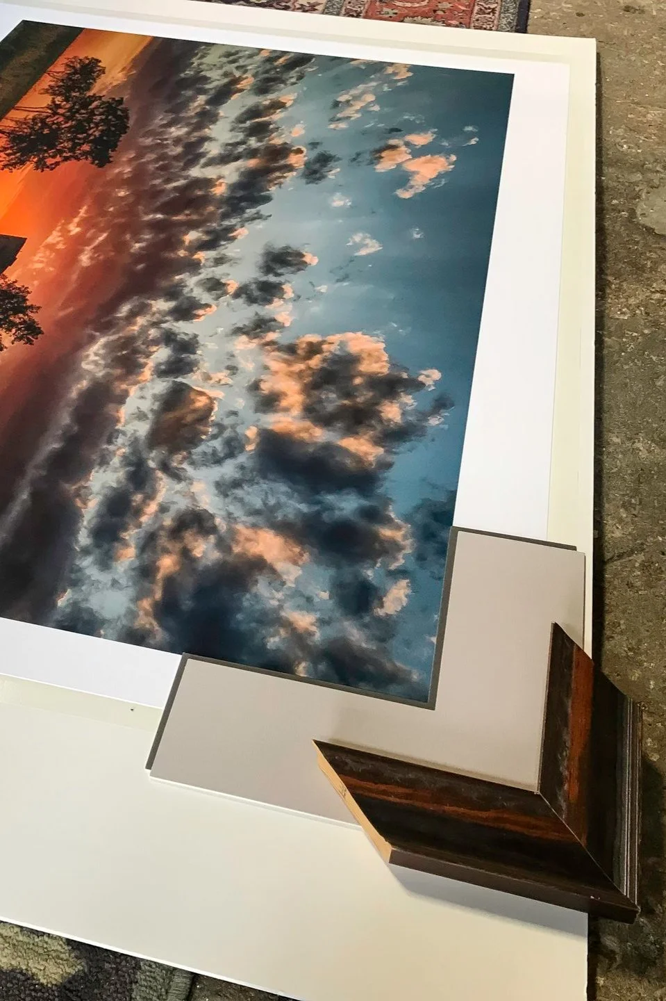 A moulding sample laid out with a mat sample on an image to see the appearance so we can better choose the mat to use for the image.